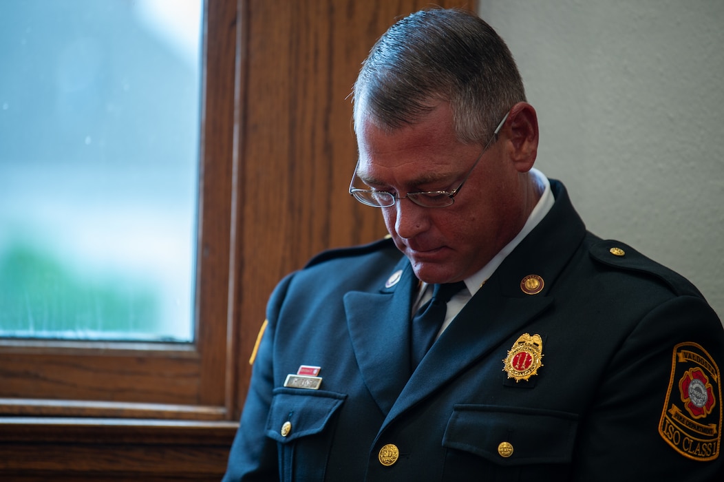 A Valdosta fireman bows his head during a prayer before a 9/11 memorial at Lowndes County Courthouse, Valdosta, Georgia, Sept. 11, 2024. The prayer reminded attendees that about the resiliency and grit of the American citizens. (U.S. Air Force photo by Airman 1st Class Iain Stanley)