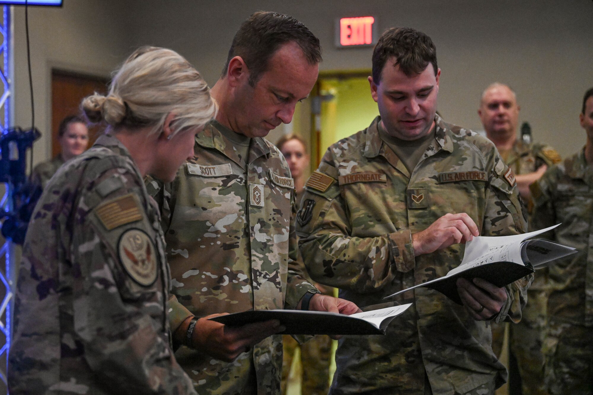 Airmen look through a book.