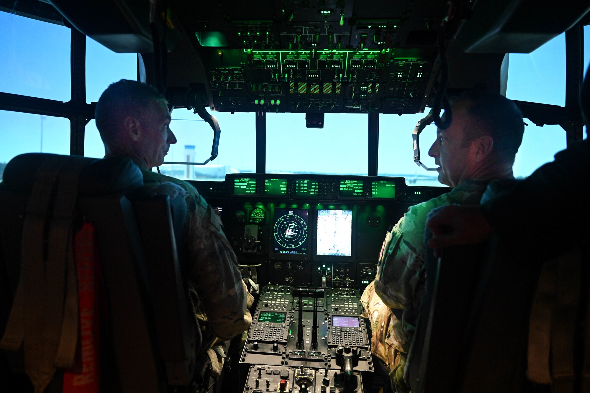 Airmen sit in a training simulator.
