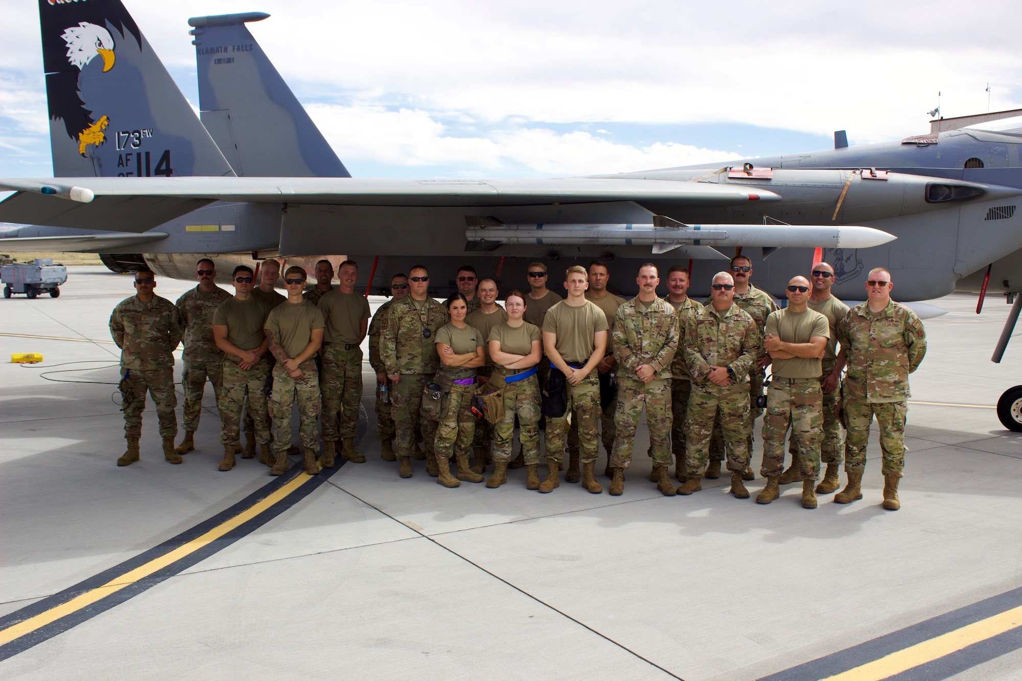 Weapons Load Crew teams pose in front of F-15 for picture after Sunset Showdown.