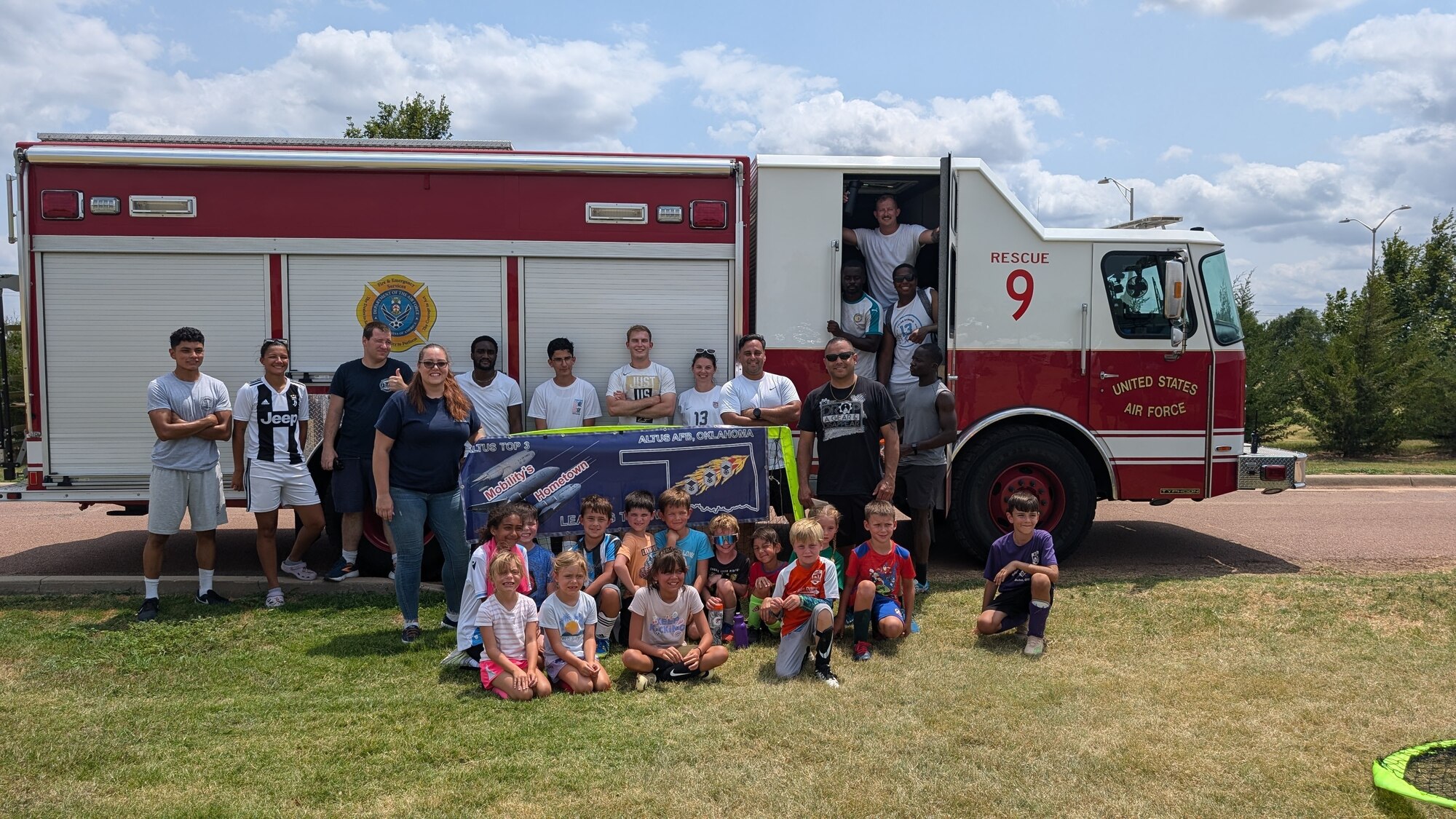 U.S. Air Force Airmen pose with children from the local community at Altus Air Force Base, Oklahoma, July 27, 2024. The Altus AFB Football Club hosted a soccer camp for children of military members. (courtesy photo)