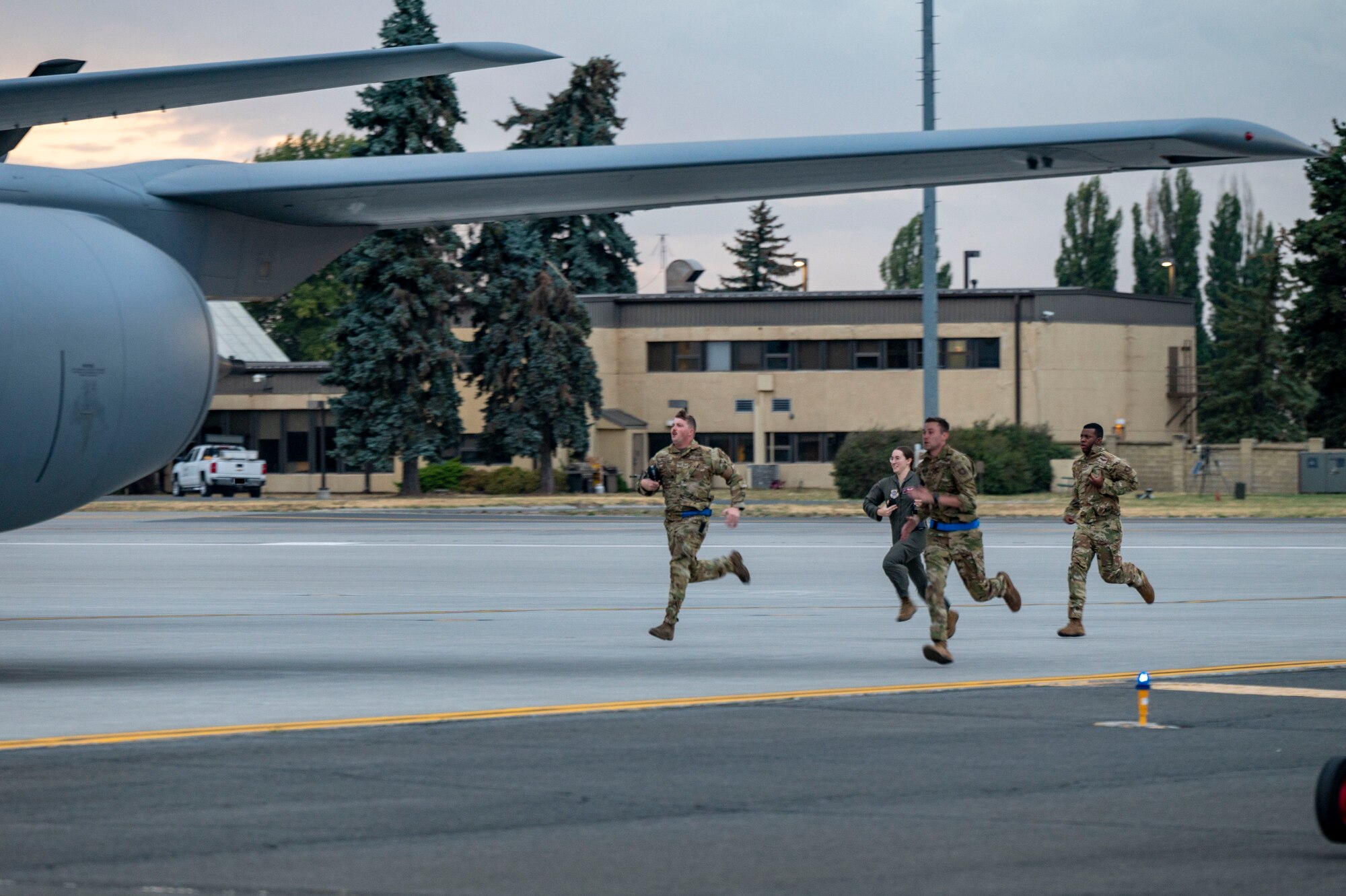 Airmen run to a jet.