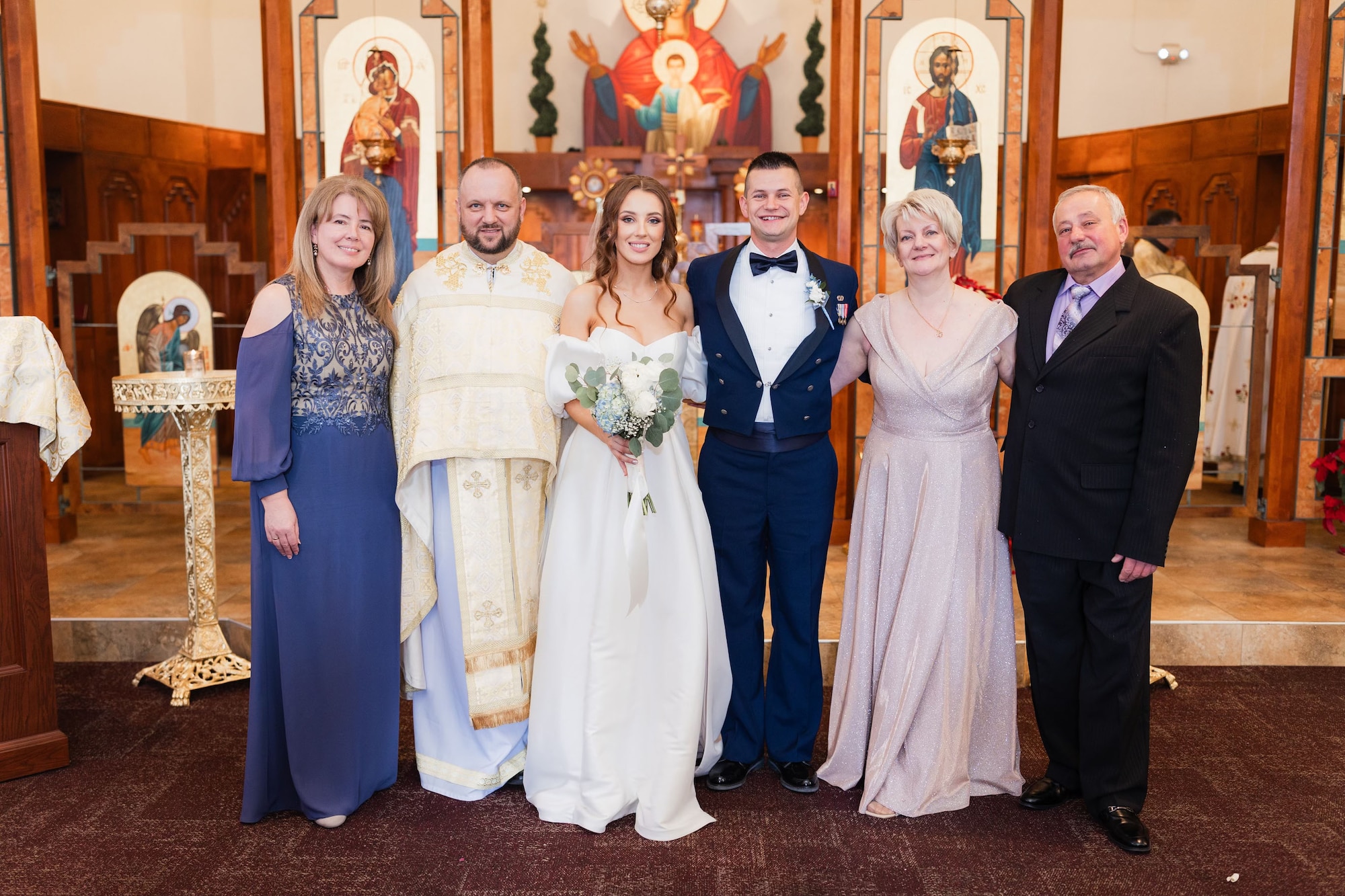 U.S. Air Force Senior Airman Mykhailo Khromiak (middle right), 56th Logistics Readiness Squadron ground transportation operator, smiles for a photo with his wife, Yordana Khromiak (middle left), and their family on their wedding
