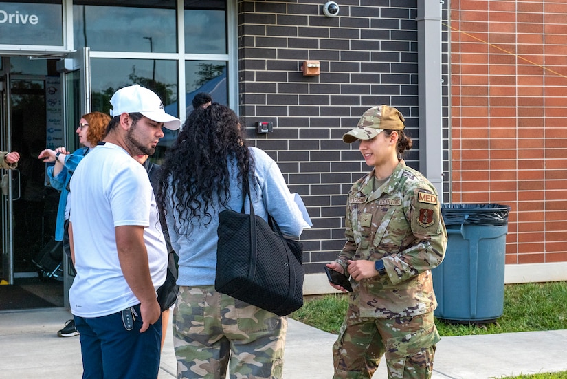 An airman speaks to a couple.