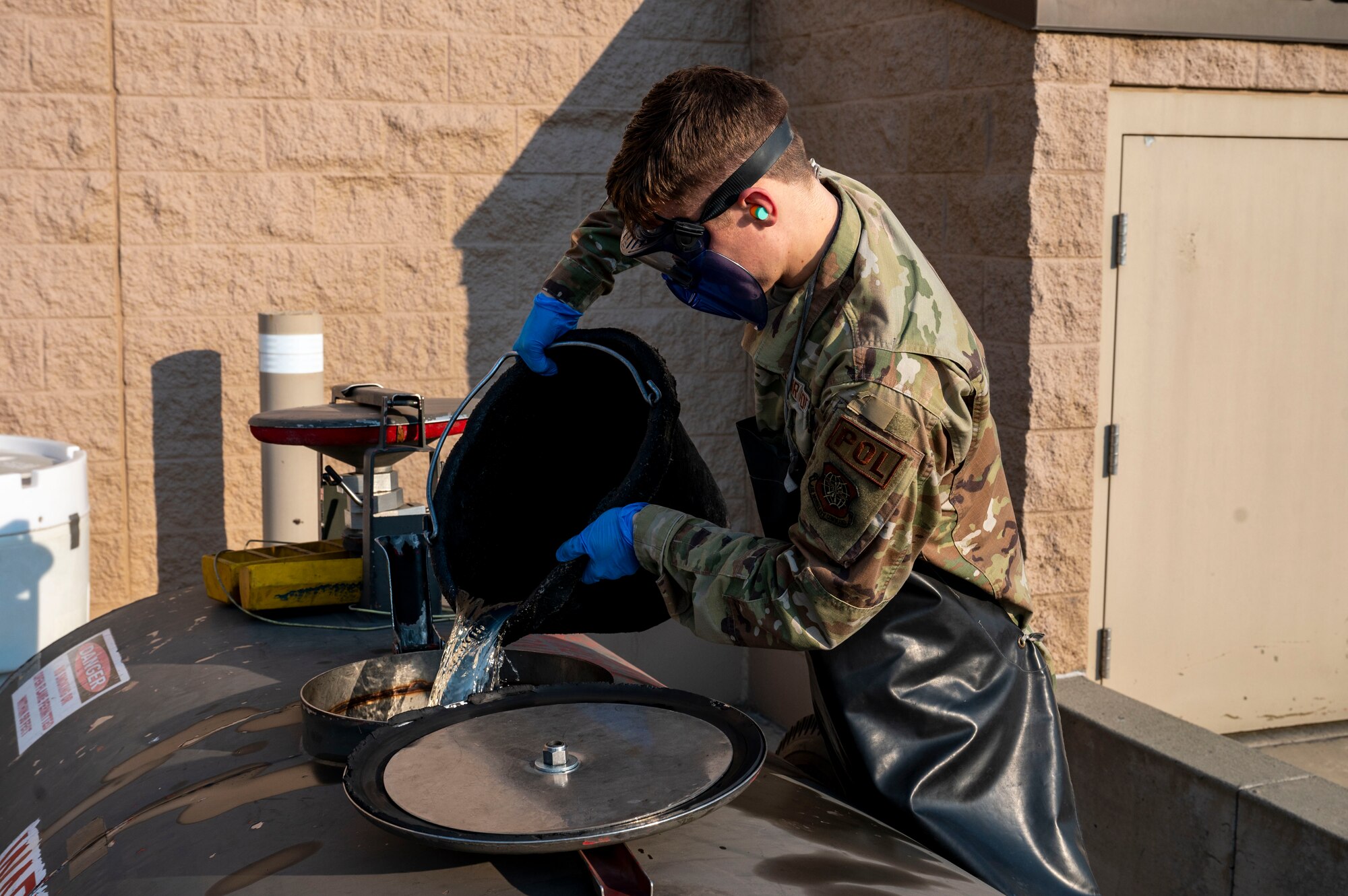 An Airman dumps fuel into a container.