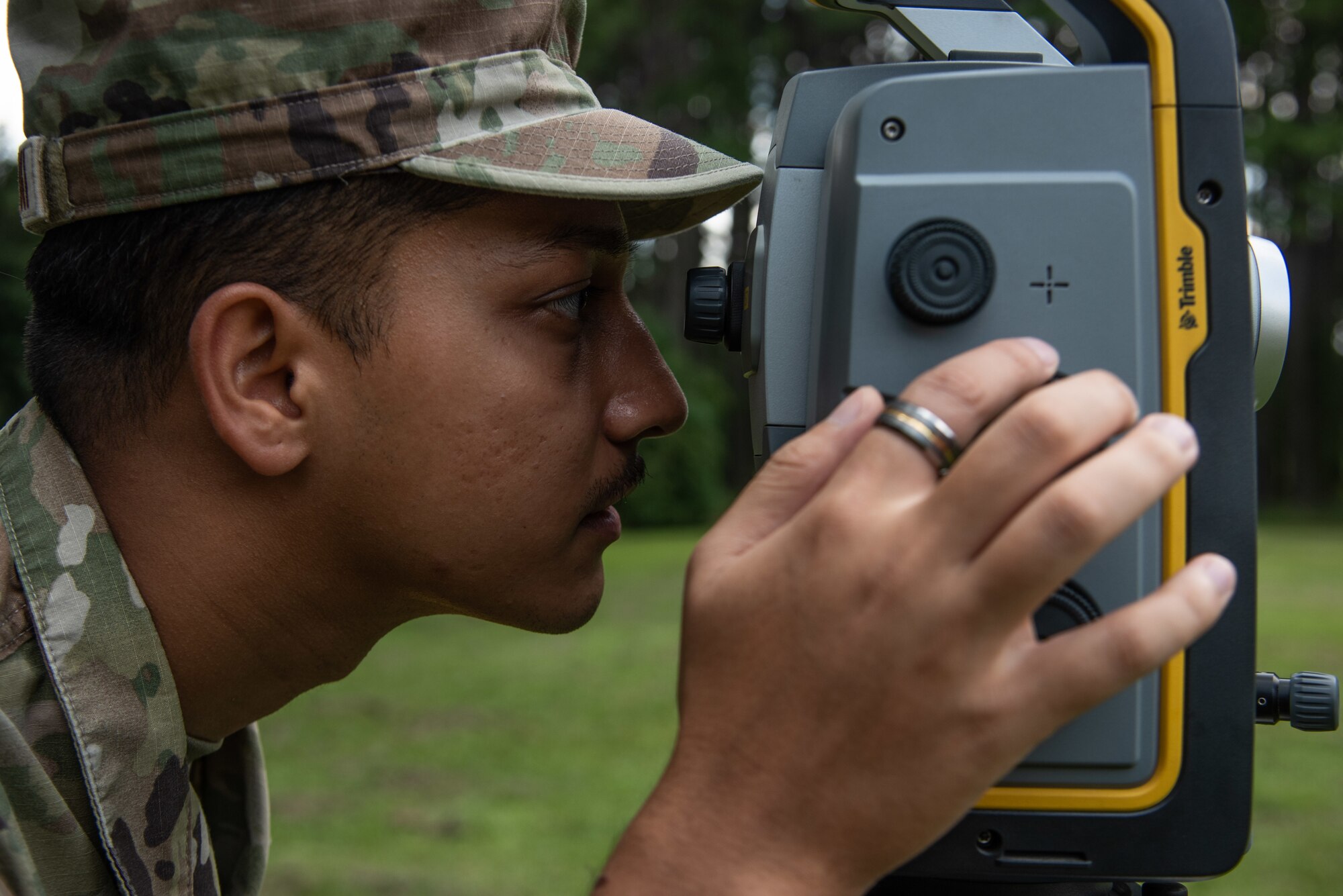 A1C Sanjay Budhathoki, 4th CES engineering journeyman, peers through the lens viewfinder of a GPS.