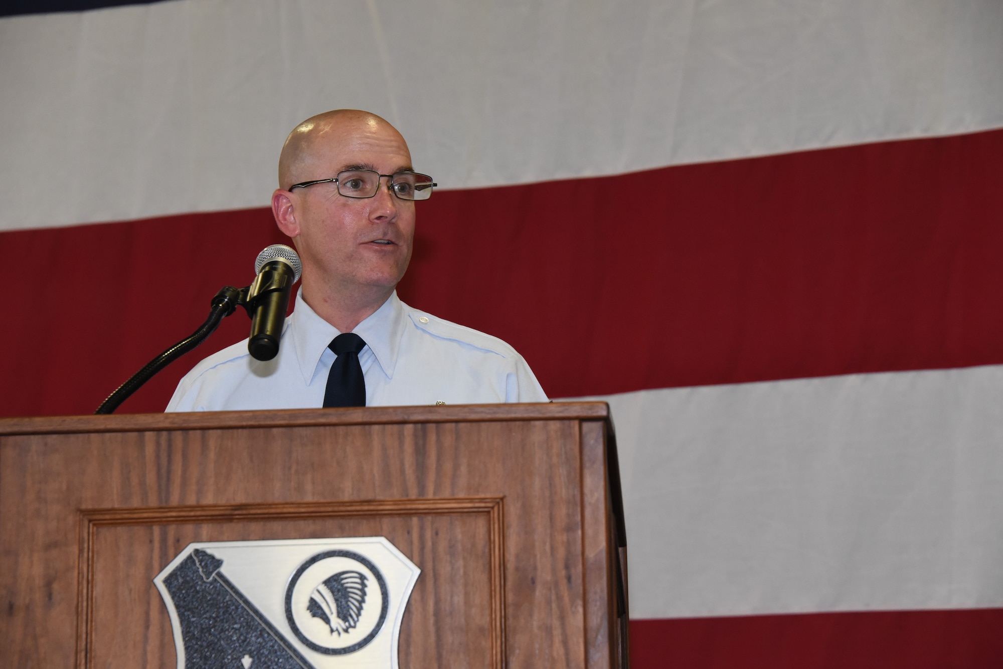 Retired Chief Master Sgt. Bill Horay speaks while standing behind a podium