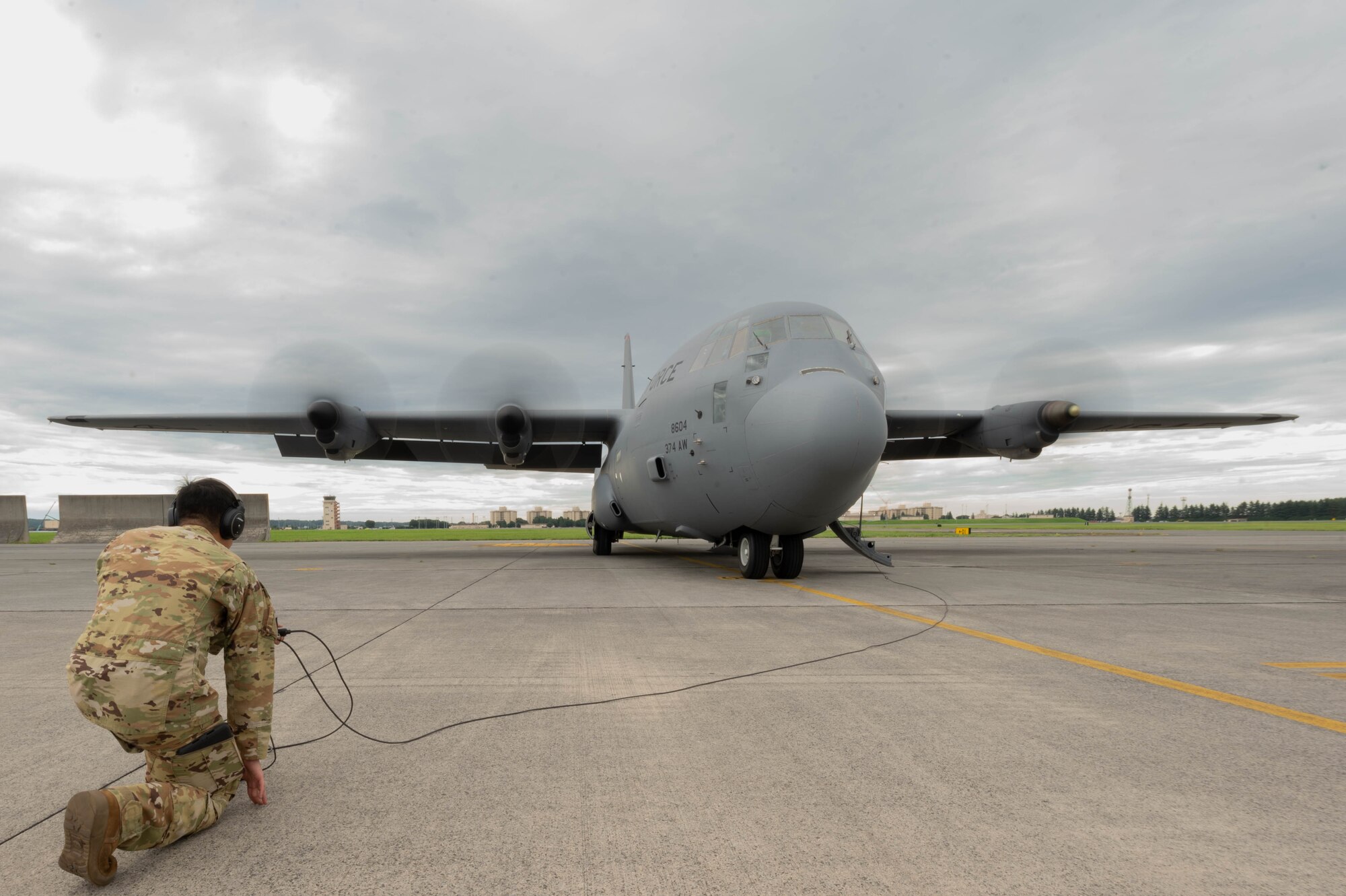 An aircraft loadmaster performs pre-flight safety checks on the aircraft.