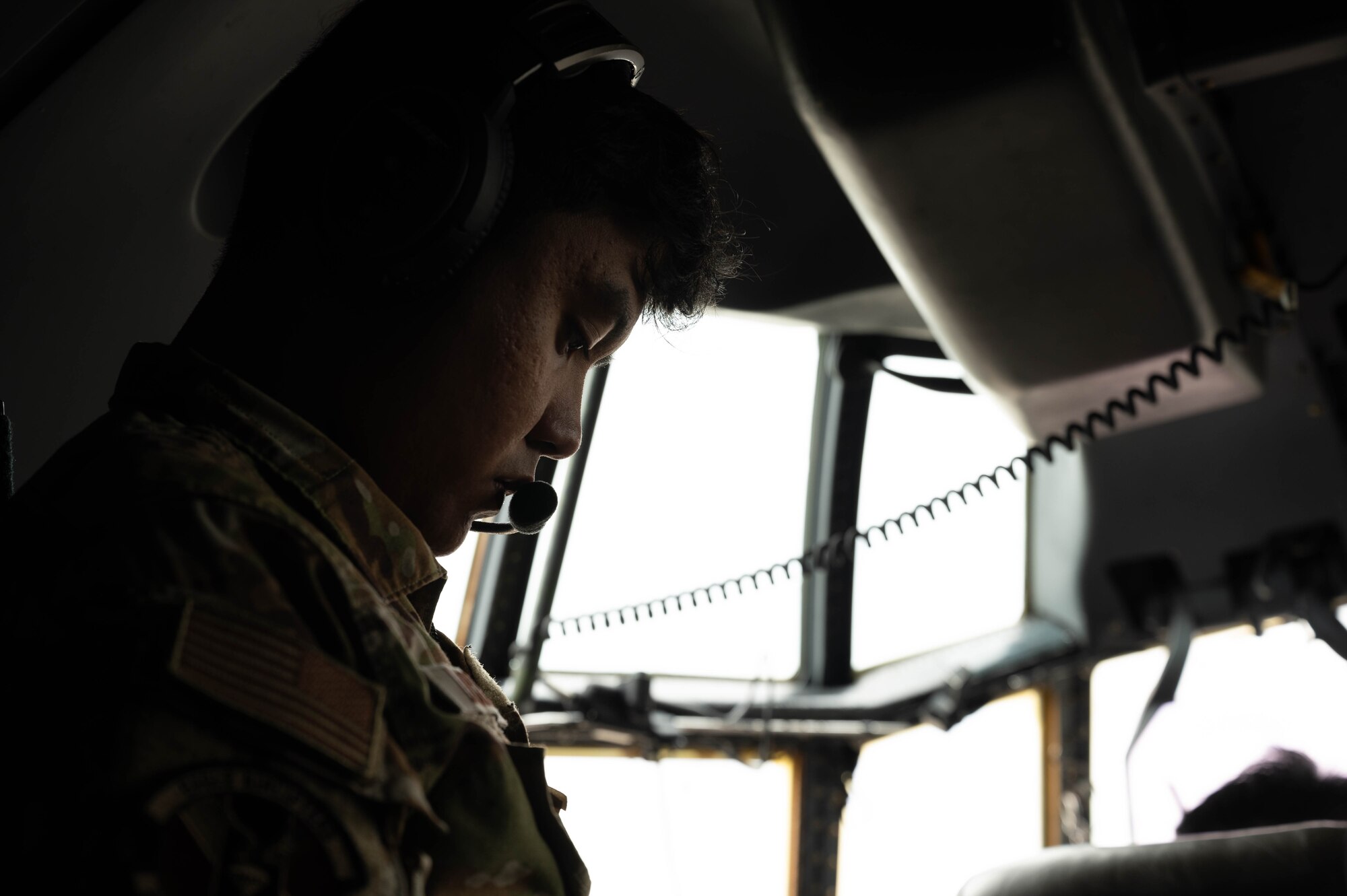 An aircraft loadmaster performs pre-flight checks.