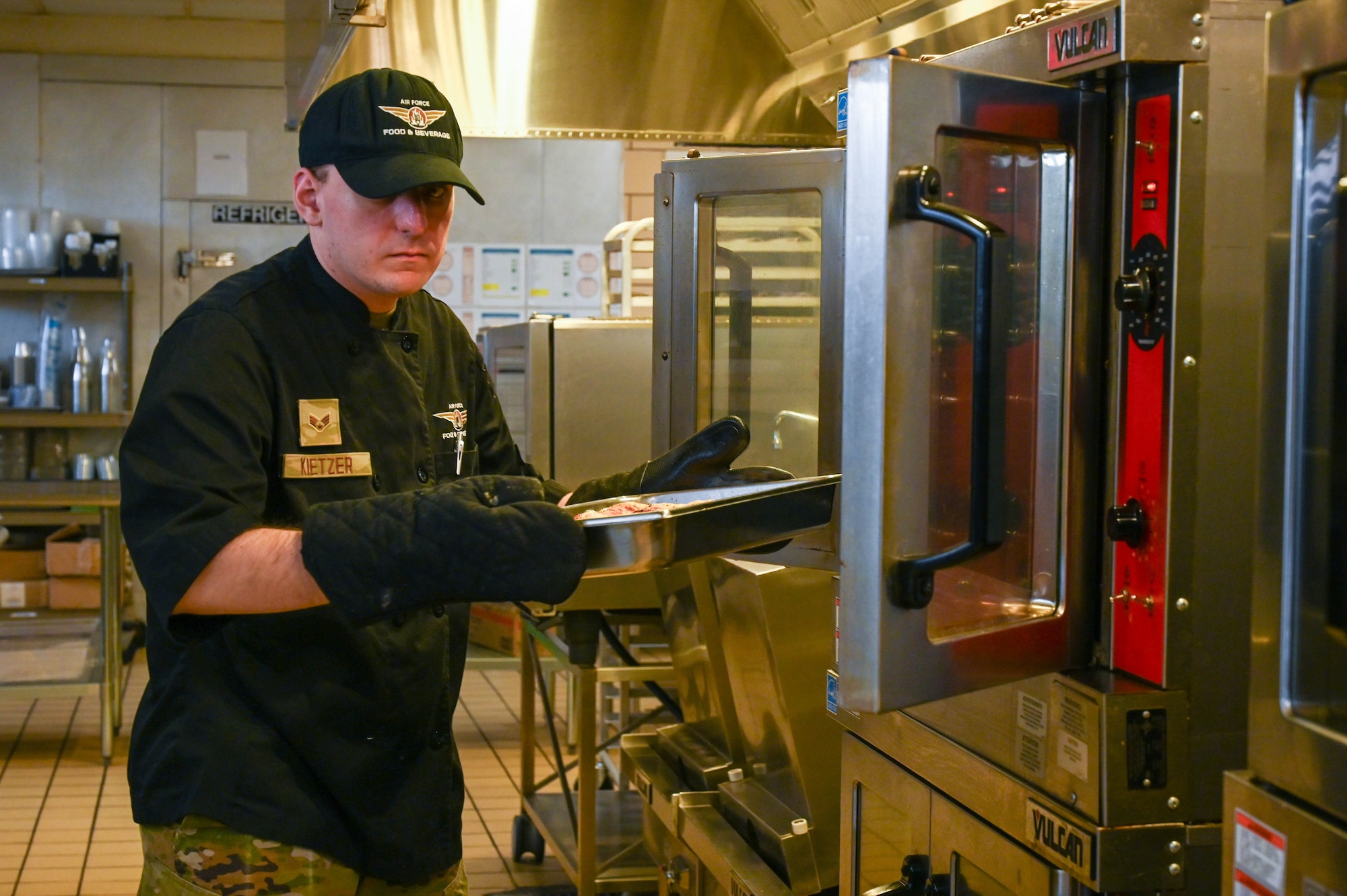 U.S. Air Force Senior Airman Michael Kietzer, 97th Force Support Squadron food services apprentice, removes a pan of cooked poultry from the oven at the Hangar 97 dining facility at Altus Air Force Base, Sept. 5, 2024. The facility, which was upgraded in 2022, provides a variety of meals through different cooking techniques. (U.S. Air Force photo by Airman 1st Class Heidi Bucins)