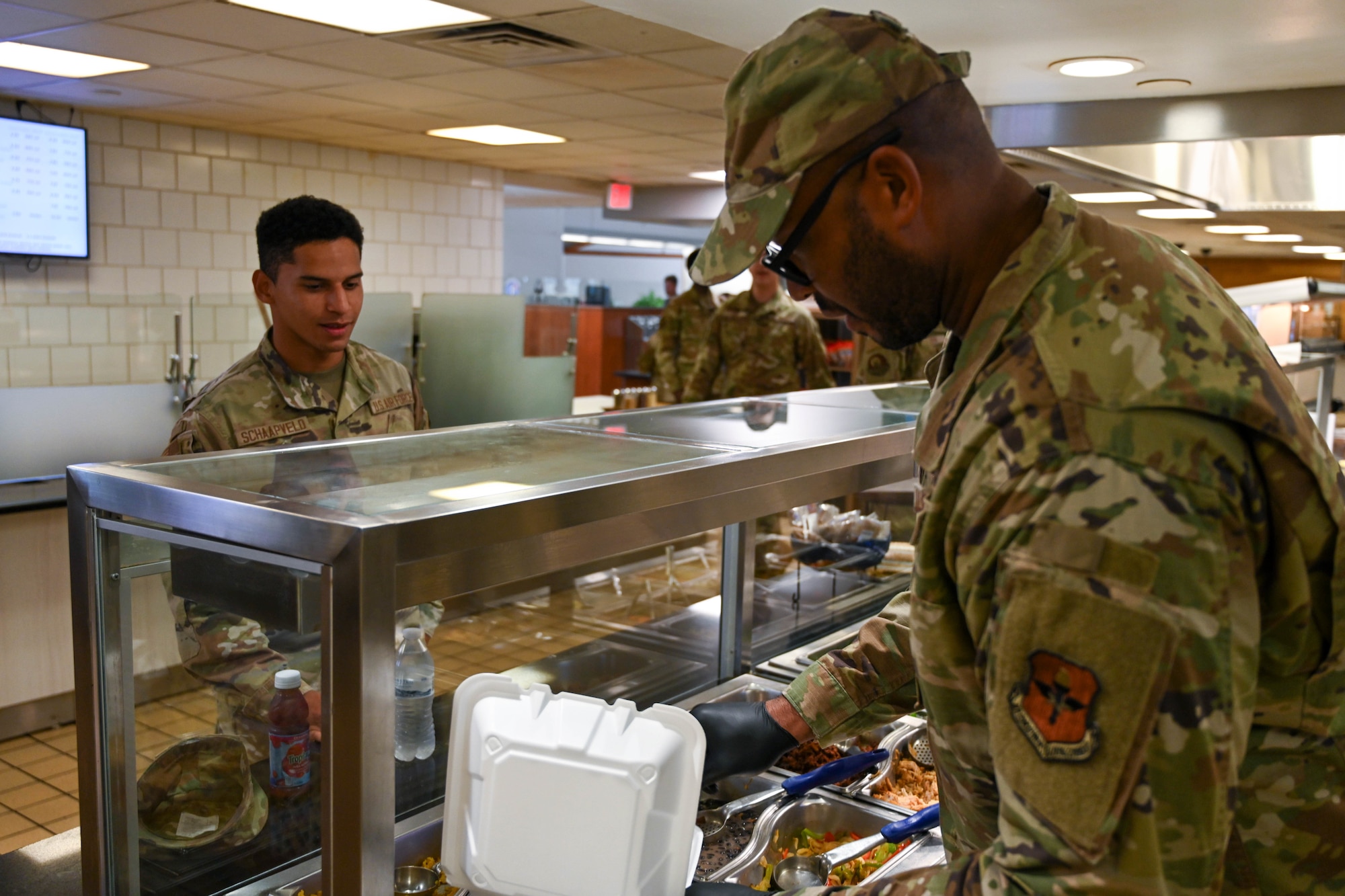 U.S. Air Force Staff Sgt. Victor Calcote, 97th Force Support Squadron dining facility manager, prepares a plate for Senior Airman Elijah Schaapveld, 97th Healthcare Operations Squadron front desk clerk, at Altus Air Force Base (AFB), Oklahoma, Sept. 6, 2024. The Hangar 97 dining facility is an essential part of the Altus AFB mission, providing Airmen with three meals a day. (U.S. Air Force photo by Senior Airman Miyah Gray)