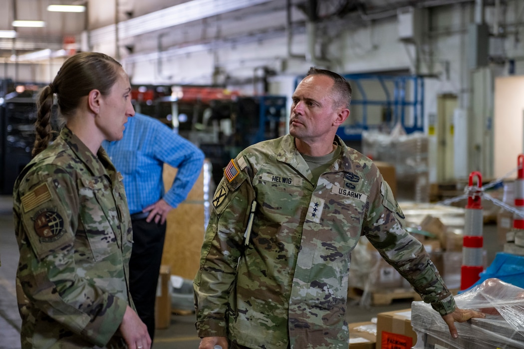 Army Lt. Gen. speaks with a logistics Airman in a warehouse