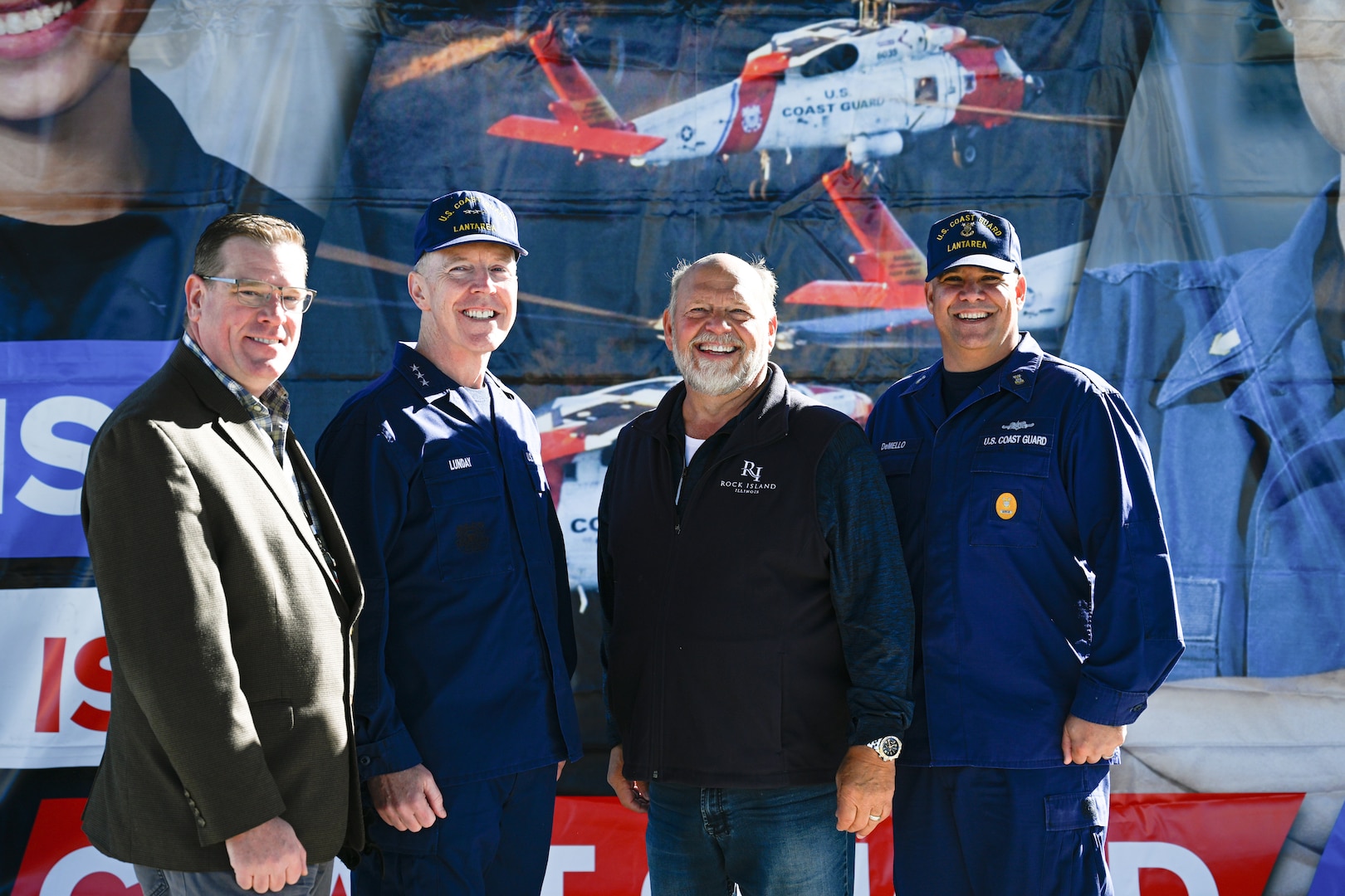 The Director of Community Development for the city of Bettendorf, Iowa, Mark Hunt, left, U.S. Coast Guard Vice Adm. Kevin Lunday, commander of Atlantic Area, middle left, the Mayor of Rock Island, Illinois, Mike Thoms, middle right, and Coast Guard Master Chief Petty Officer Jeremy DeMello, command master chief of Atlantic Area, right, pose for a group photo at the ‘Mission Mighty Mississippi’ event, Oct. 21, 2023, in Rock Island, Illinois. Lunday and crew members hosted the event to showcase Coast Guard capabilities and career opportunities in the region. (U.S. Coast Guard photo by Petty Officer 3rd Class Kate Kilroy)