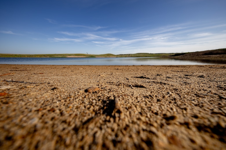 Blue sky is in the background with red sand in the foreground.
