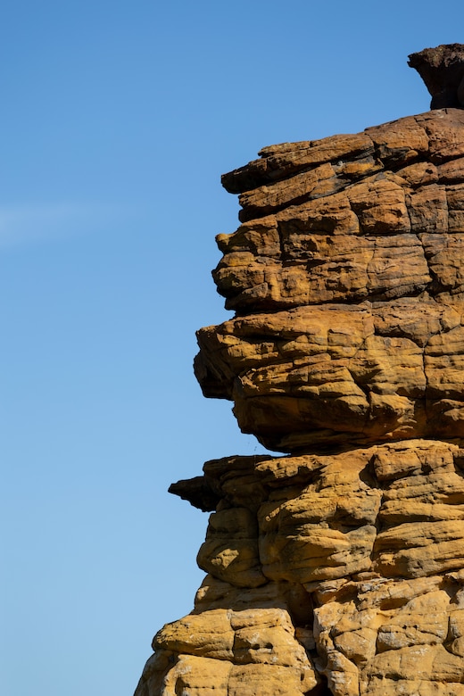 A rock formation is in the left and blue sky in the right.