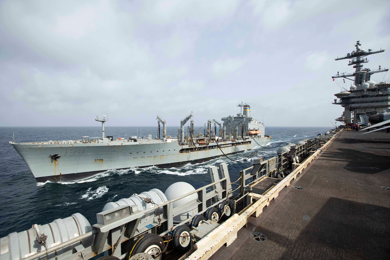 A tanker ship refuels another ship while at sea.