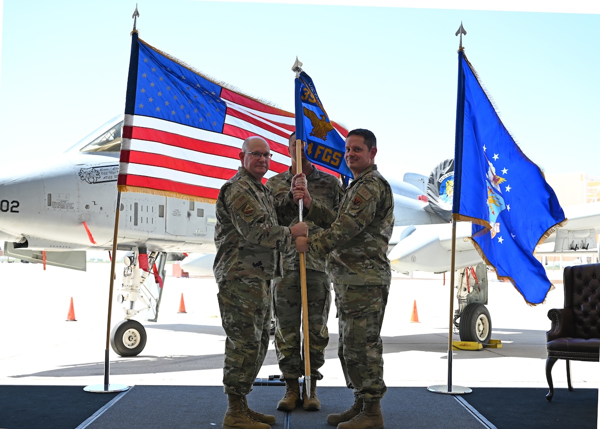 U.S. Air Force Maj. Benjamin Abshire, 354th Fighter Generation Squadron commander, right, relinquishes command to Col. Clarence McRae, 355th Maintenance Group commander, left, during the 354th FGS inactivation ceremony at Davis-Monthan Air Force Base, Arizona, Sept. 13, 2024. The 354th FGS was the first fighter generation squadron in Air Combat Command to deploy under the USAF Force Generation Model in October, 2023. (U.S. Air Force photo by Staff Sgt. Abbey Rieves)