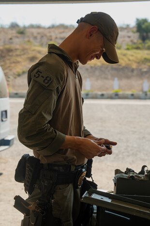 U.S. Marine Corps Lance Cpl. Hunter A. Dalecke-Sabandith, a special reaction team entryman, with the Provost Marshal's Office, Headquarters and Service Battalion, Marine Corps Recruit Depot San Diego, loads a pistol magazine at Marine Corps Air Station Miramar, California, Sept. 9, 2024. The members of SRT are military police officers with advanced training responsible for responding to emergencies such as active shooter and hostage situations. During the range, SRT completed their monthly qualification with the M18 service pistol. (U.S. Marine Corps photo by Lance Cpl. Janell B. Alvarez)