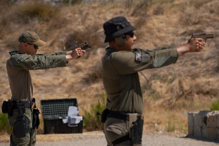U.S. Marine Corps Lance Cpl. Hunter A. Dalecke-Sabandith, left, special reaction team entryman and Sgt. Jorge L. Moreno-Arroyos, right, special reaction team leader, with the Provost Marshal's Office, Headquarters and Service Battalion, Marine Corps Recruit Depot San Diego, fire a M18 military service pistol at Marine Corps Air Station Miramar, California, Sept. 9, 2024. The members of SRT are military police officers with advanced training responsible for responding to emergencies such as active shooter and hostage situations. During the range SRT completed their monthly qualification with the M18 service pistol. (U.S. Marine Corps photo by Lance Cpl. Janell B. Alvarez)