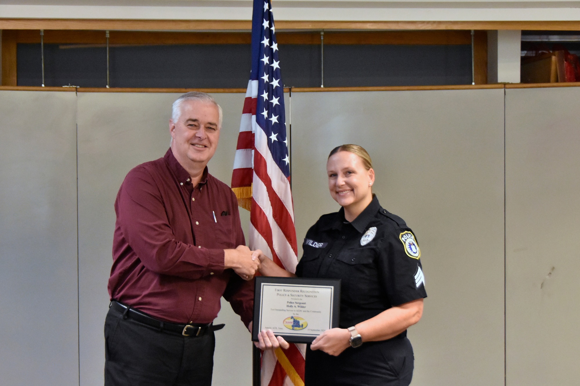 Lynn Sebourn, Arnold Community Council vice president and Tullahoma mayor, presents Arnold Air Force Base Police Sgt. Holly Wilder with a plaque recognizing her as an outstanding first responder during the Sept. 10, 2024, meeting of the ACC at the Gossick Leadership Center at Arnold AFB, Tenn., headquarters of Arnold Engineering Development Complex. Since 9/11, the ACC has recognized first responders from Arnold AFB. The ACC is a nonprofit founded in 2000 to support AEDC and represent more than a dozen Tennessee and Alabama counties. (U.S. Air Force photo by Bradley Hicks)