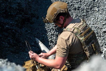 U.S. Air Force Staff Sgt. Sterling Horton, an explosive ordnance disposal journeyman assigned to the 316th Civil Engineer Squadron, examines simulated unexploded explosive ordnance during a bivouac training exercise at Fort Indiantown Gap, Pa., Sept. 5, 2024. During the training, EOD Airmen assessed the ordnance’s type, condition, and potential hazards before neutralization. (U.S. Air Force photo by Senior Airman Bridgitte Taylor)