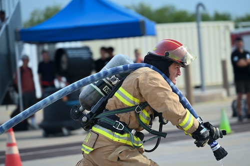 A 312th Training Squadron instructor pulls a firehose during the 12th Annual Blood, Sweat & Stairs event at the Louis F. Garland Department of Defense Fire Academy, Goodfellow Air Force Base, Texas, Sept. 13, 2024. Blood, Sweat & Stairs is an event that pays tribute to the 343 firefighters, 71 law enforcement officers, eight paramedics and 55 military personnel who lost their lives during the 9/11 attacks.  (U.S. Air Force photo by Airman 1st Class Madi Collier)