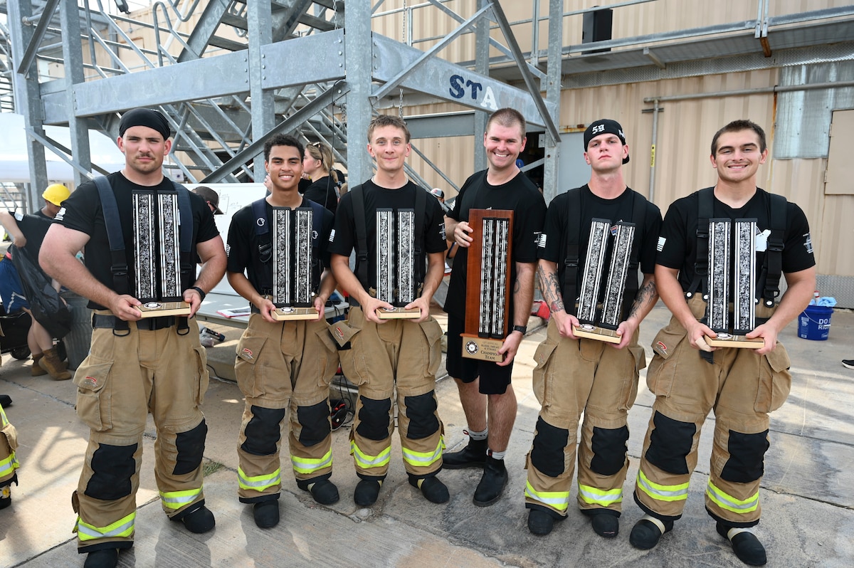 Members of  “Air Force 1” celebrate their victory after the final round of the combat challenge during the 12th Annual Blood, Sweat & Stairs event at the Louis F. Garland Department of Defense Fire Academy, Goodfellow Air Force Base, Texas, Sept. 13, 2024. Students and instructors faced off in timed endurance and strength challenges through multiple rounds competing as teams of five throughout the day; these challenges were inspired by different abilities firefighters must have when participating in rescue operations such as the 9/11 terrorist attacks. (U.S. Air Force photo by Airman 1st Class Madi Collier)