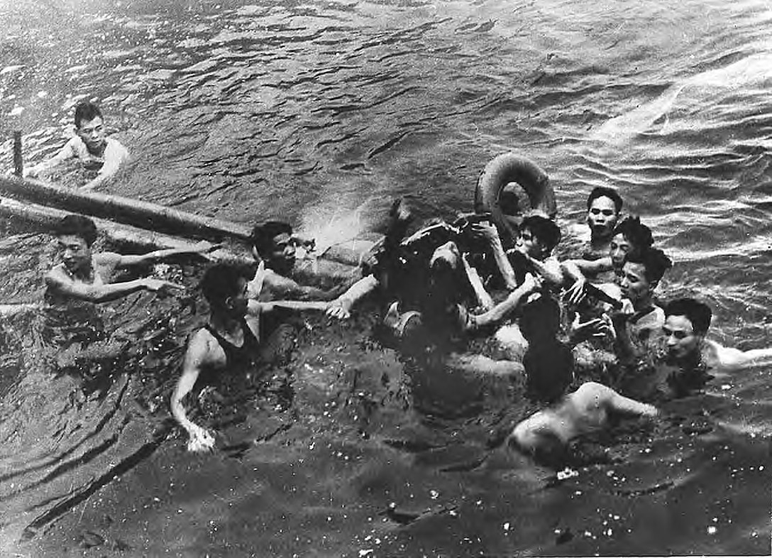 Vietnamese civilians surround Lt. Cmdr. John S. McCain, center, as he floats in Truc Bach Lake, in Hanoi, North Vietnam, after ejecting from his damaged aircraft, Oct. 26, 1967. He was pulled to shore, then transported to Hoa Lo Prison in Hanoi (Library of Congress).