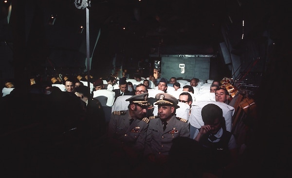 Former POWs U.S. Navy Capt. Jeremiah A. Denton, right, and U.S. Navy Capt. James A. Alfred Mulligan, left, talk during their flight on a Military Airlift Command C-141 Starlifter after being released by the North Vietnamese in February 1973 (National Archives and Records Administration 330-CFD-DD-ST-99-04242).