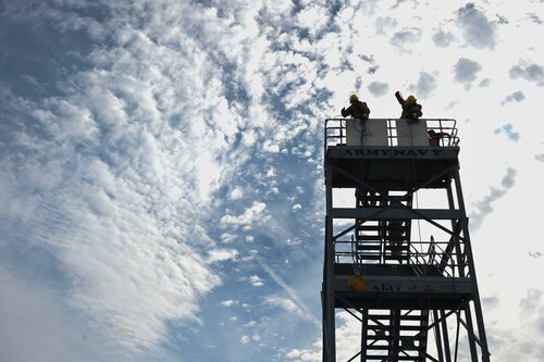Students assigned to the 312th Training Squadron hoist tools up the side of a five-story tower using rope during the 12th Annual Blood, Sweat & Stairs event at the Louis F. Garland Department of Defense Fire Academy, Goodfellow Air Force Base, Texas, Sept. 13, 2024. This obstacle simulated hoisting tools up the side of a building during an active situation, training participants for rescue operations. Each obstacle in the combat challenge demonstrated different physical abilities that were pertinent to success of rescue operations carried out by first responders after 9/11. (U.S. Air Force photo by Airman 1st Class Madi Collier)