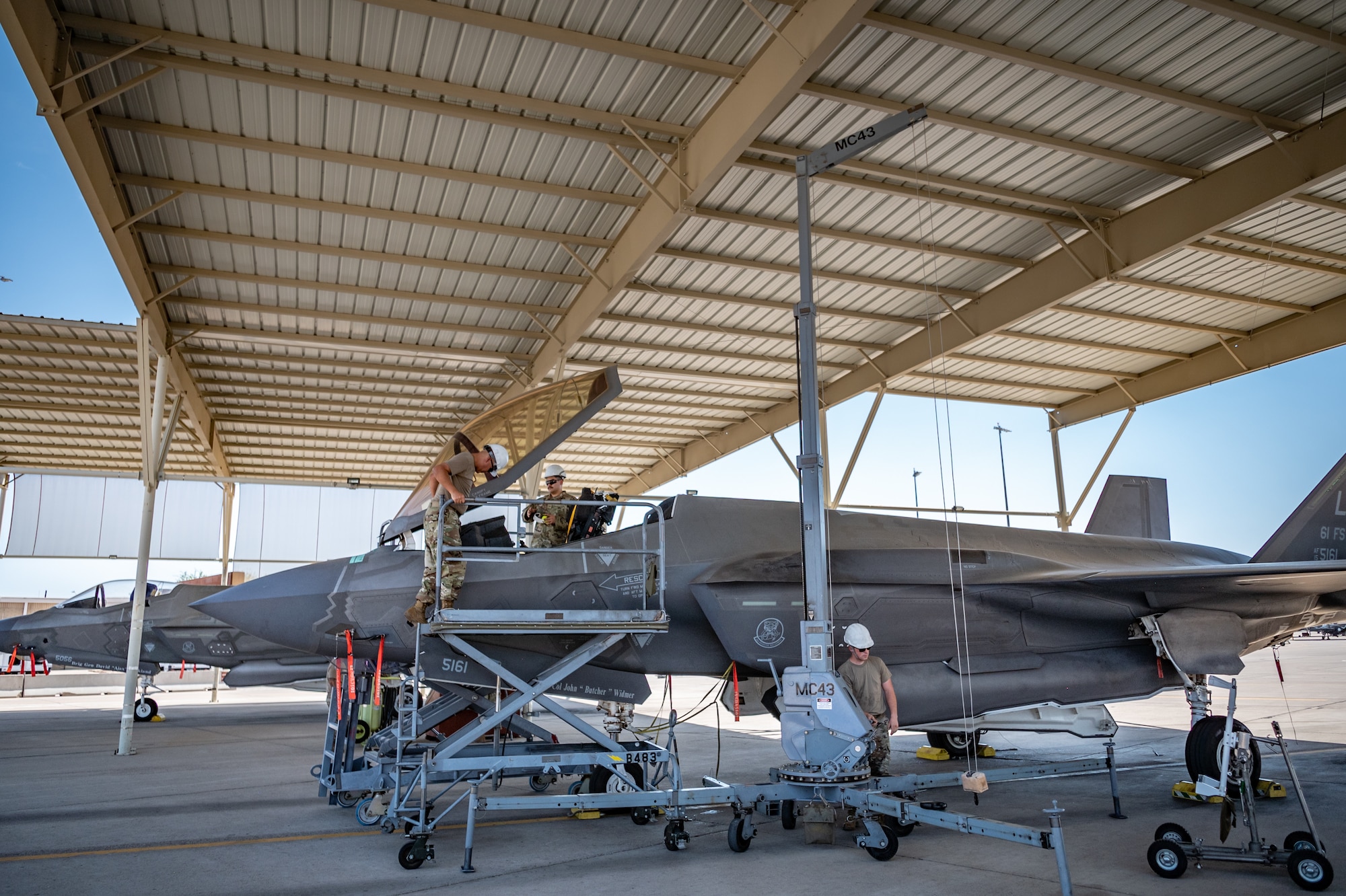 Reserve Citizen Airmen from the 944th Maintenance Group perform maintenance on an F-35 fighter jet using a hoist system at Luke Air Force Base, Ariz., Sept. 8, 2024. The team ensures the aircraft's systems are mission-ready. (U.S. Air Force photo by Tech. Sgt. Tyler J. Bolken)