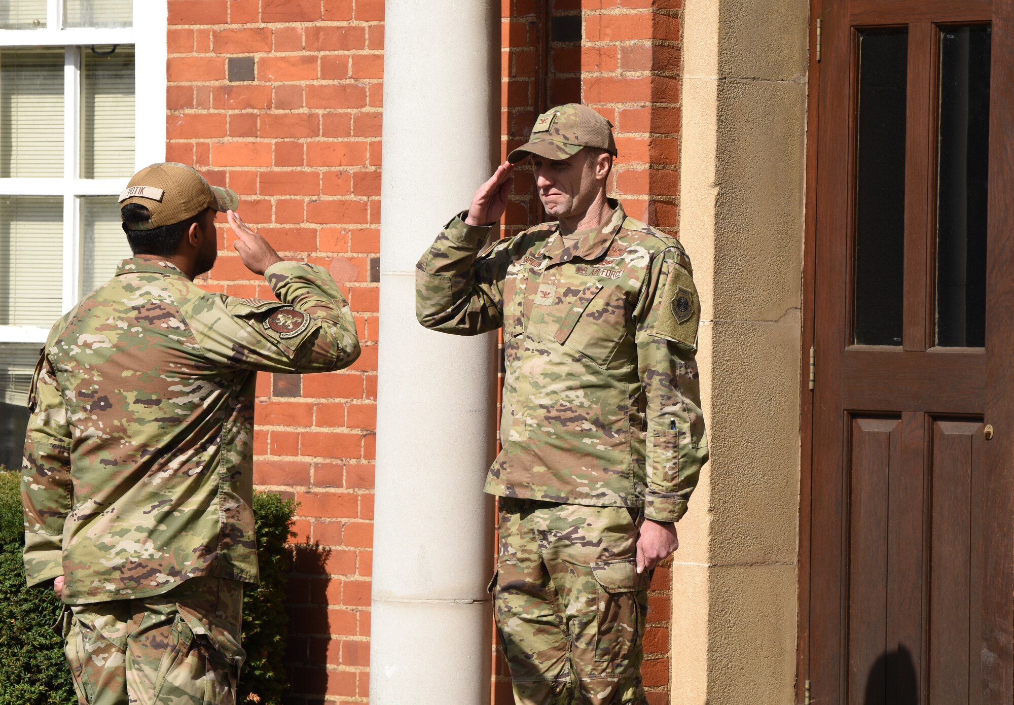 A U.S. Airman from the Team Mildenhall Honor Guard, left, salutes U.S. Air Force Col. Ryan Garlow, 100th Air Refueling Wing commander, during a retreat ceremony concluding POW/MIA Week at Royal Air Force Mildenhall, England, Sept. 13, 2024. The week remembered and honored those Americans who were prisoners of war and those who served and never returned home. (U.S. Air Force photo by Karen Abeyasekere)