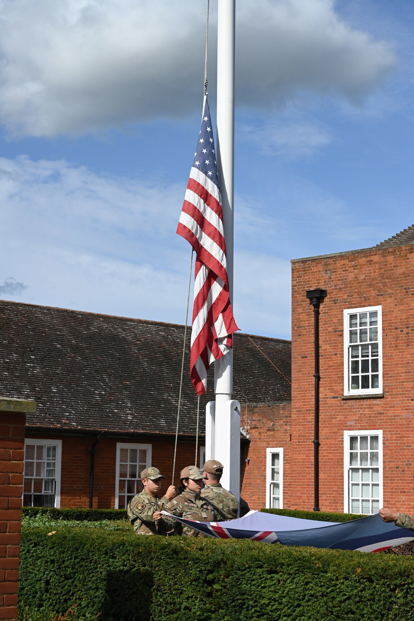 The U.S. Stars and Stripes is lowered as the Royal Air Force Ensign flag is folded during a retreat ceremony concluding POW/MIA Week at Royal Air Force Mildenhall, England, Sept. 13, 2024. The week remembered and honored those Americans who were prisoners of war and those who served and never returned home. (U.S. Air Force photo by Karen Abeyasekere)