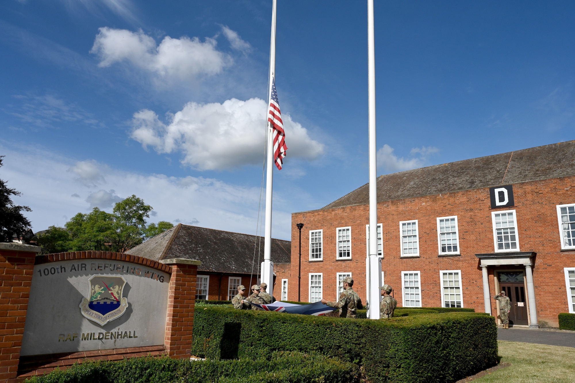 The U.S. Stars and Stripes, and Royal Air Force Ensign flags are lowered during a retreat ceremony concluding POW/MIA Week at Royal Air Force Mildenhall, England, Sept. 13, 2024. The week remembered and honored those Americans who were prisoners of war and those who served and never returned home. (U.S. Air Force photo by Karen Abeyasekere)