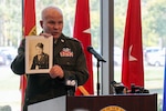 Maj. Gen. Ray Shields, the adjutant general of New York, displays a photograph of Pvt. John Greschiak, a World War II Soldier killed in action on Sept. 16, 1944, during a ceremony at which he was posthumously awarded the New York State Conspicuous Service Cross at New York National Guard headquarters in Latham. New York, Sept. 16, 2024. Shields presented the award to the Soldiers niece and grandniece.