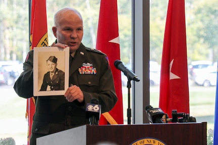 Maj. Gen. Ray Shields, the adjutant general of New York, displays a photograph of Pvt. John Greschiak, a World War II Soldier killed in action on Sept. 16, 1944, during a ceremony at which he was posthumously awarded the New York State Conspicuous Service Cross at New York National Guard headquarters in Latham. New York, Sept. 16, 2024. Shields presented the award to the Soldiers niece and grandniece.