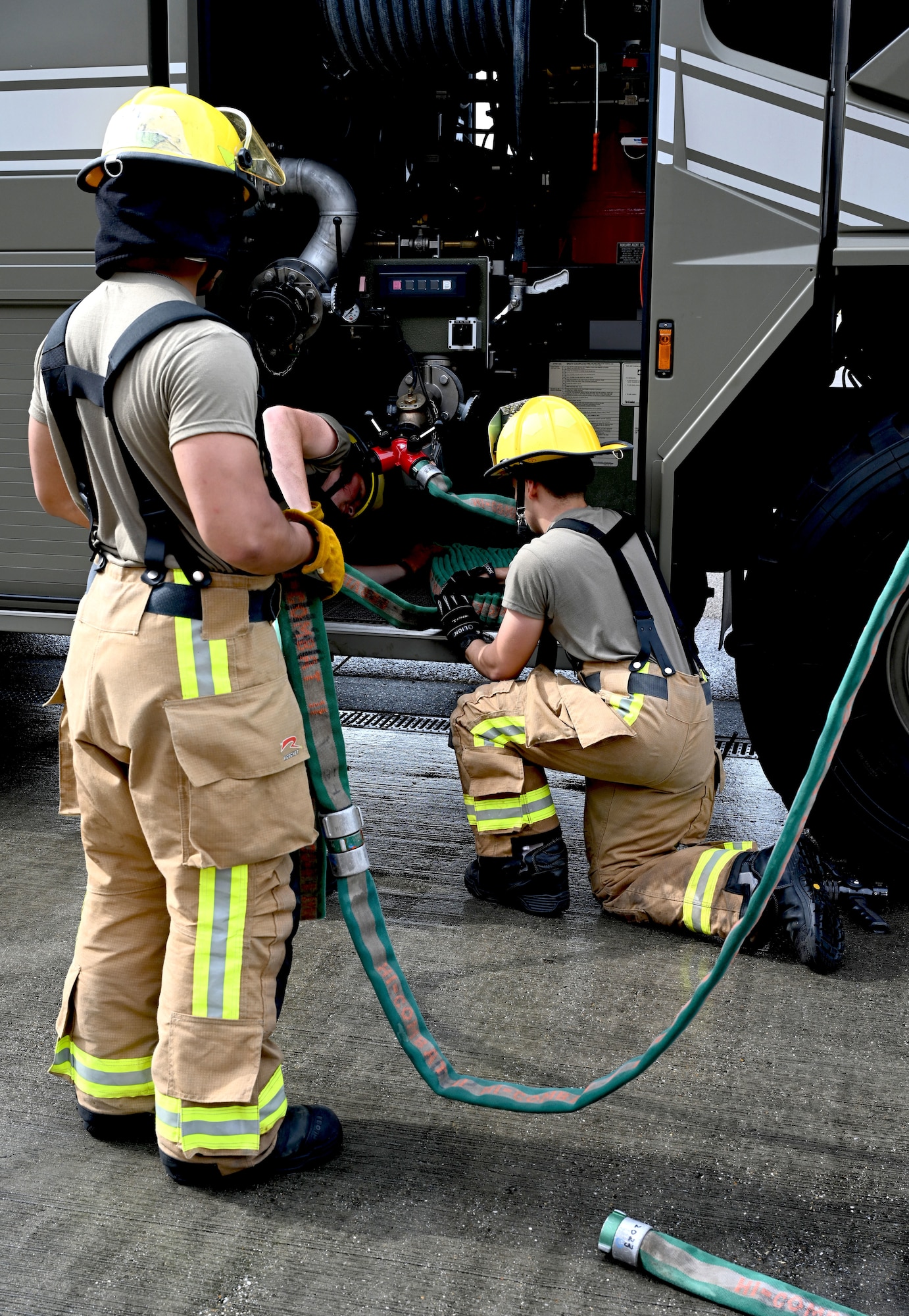 U.S. Air Force 100th Civil Engineer Squadron Fire Department firefighter rookies learn to properly fold and pack hoses onto a fire truck as part of their tasks during “Rookie Academy” at Royal Air Force Mildenhall, England, Aug. 28, 2024. The Rookie Academy is an intense training program put together by Staff Sgt. Connor Nance, 100th CES Fire Department assistant chief of training, and taught by multiple experienced firefighters. It condenses four months of training for new firefighters into three weeks, ensuring they all learn the same way, so they receive a high-quality level of training while maintaining that consistency of training across the board. This in turn gives the rookies a head-start on completing their career-based training, putting them ahead of their peers at other bases. (U.S. Air Force photo by Karen Abeyasekere)