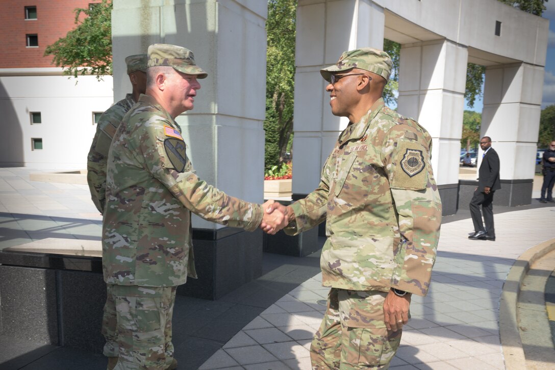 Defense Logistics Agency Director Army Lt. Gen. Army Lt. Gen. Mark Simerly, left, greets Chairman of the Joint Chiefs of Staff Air Force Gen. Charles Q. Brown Jr., right, during the Worldwide Logistics Symposium at the McNamara Headquarters Complex at Fort Belvoir, Virginia