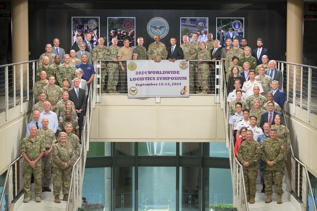 A group of people gathered for a photo at the Defense Logistics Agency Headquarters building in Fort Belvoir, Virginia during a logistics leadership solutions based symposium
