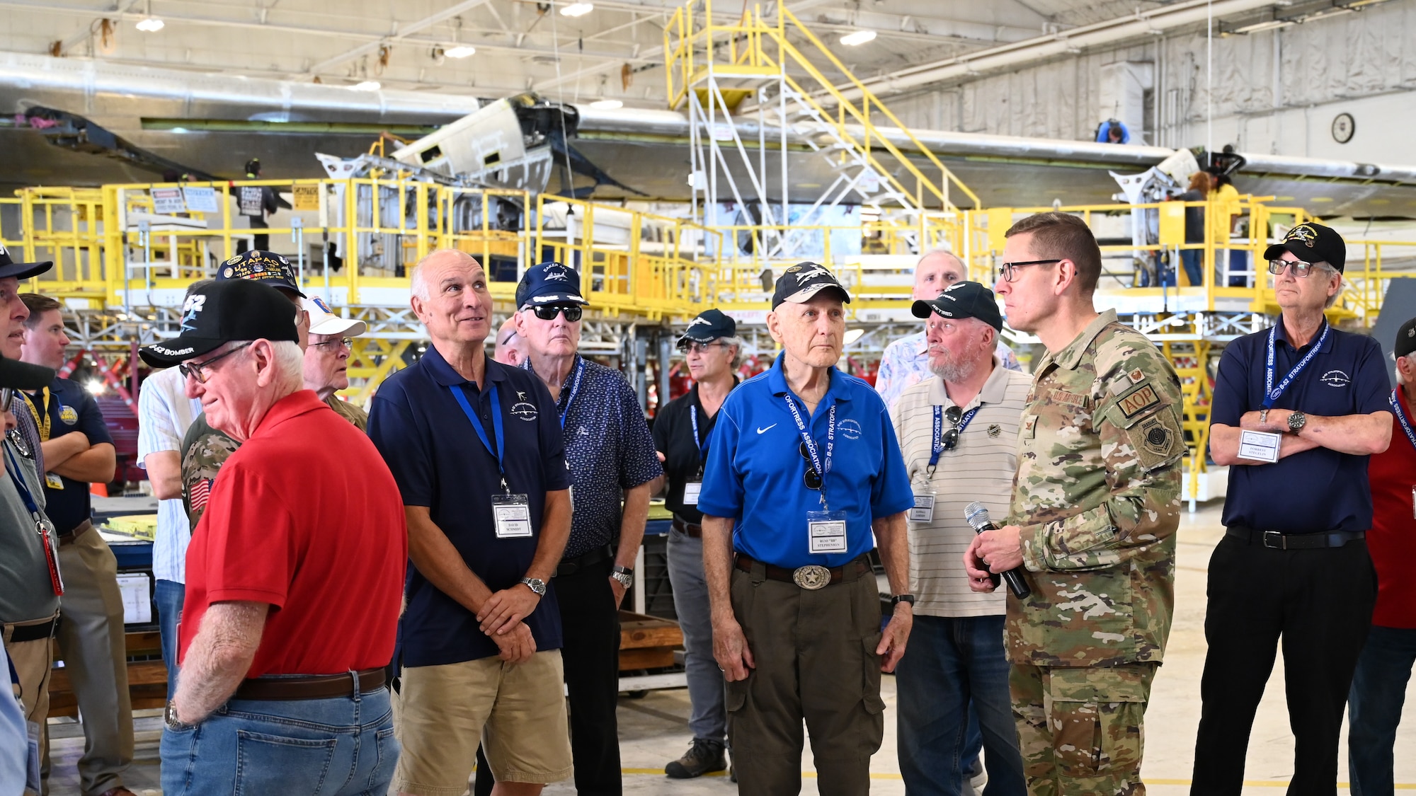 Group of people looking at aircraft in industrial space.
