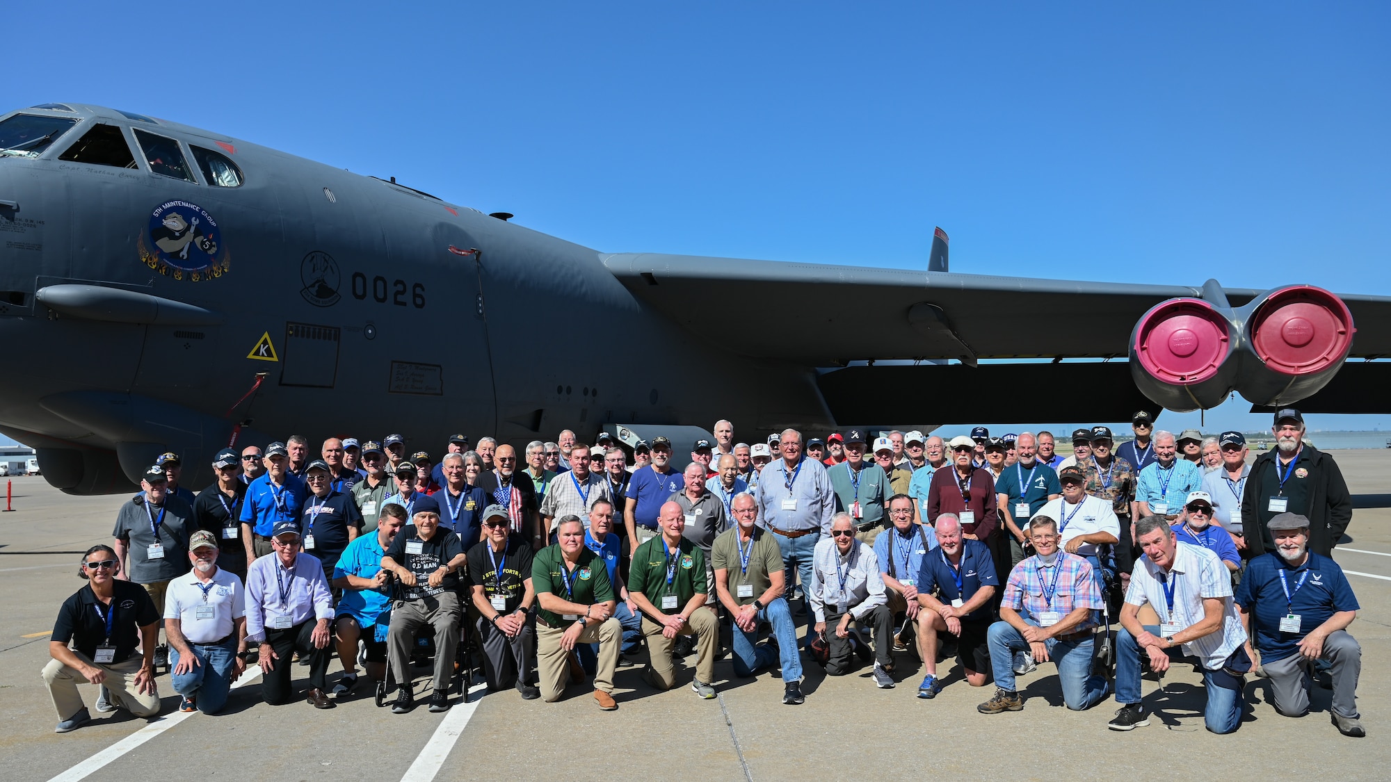 People posing for group photo in front of B-52.