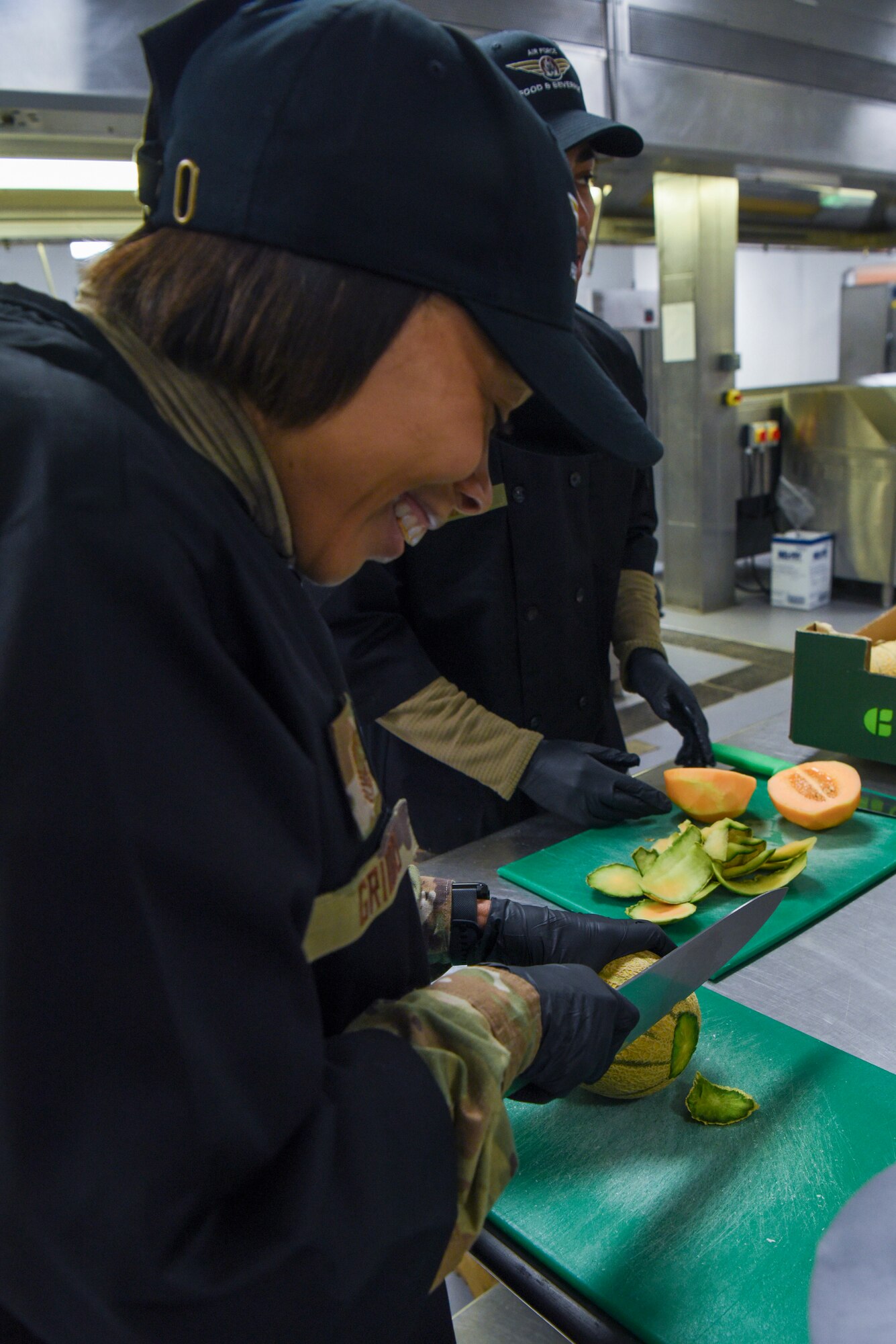 U.S. Air Force Chief Master Sgt. Tiffany Griego, 100th Air Refueling Wing command chief, cuts a cantaloupe during a “Day in the Life” immersion with the 100th Force Support Squadron Gateway Dining Facility at Royal Air Force Mildenhall, England, Sept. 13, 2024.