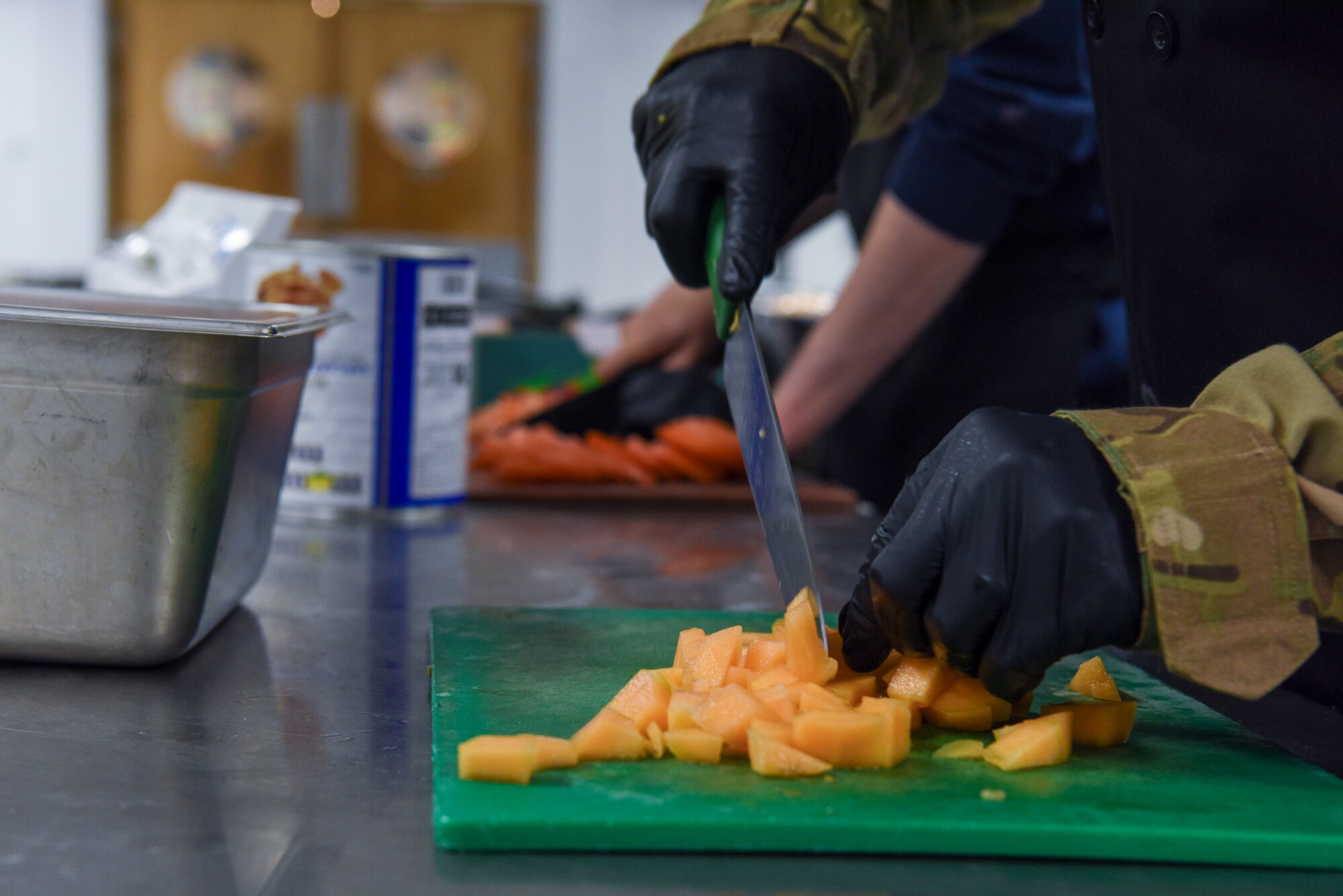 U.S. Air Force Col. Joseph Wall, 100th Air Refueling Wing deputy commander, cuts a cantaloupe during a “Day in the Life” immersion with the 100th Force Support Squadron Gateway Dining Facility at Royal Air Force Mildenhall, England, Sept. 13, 2024.