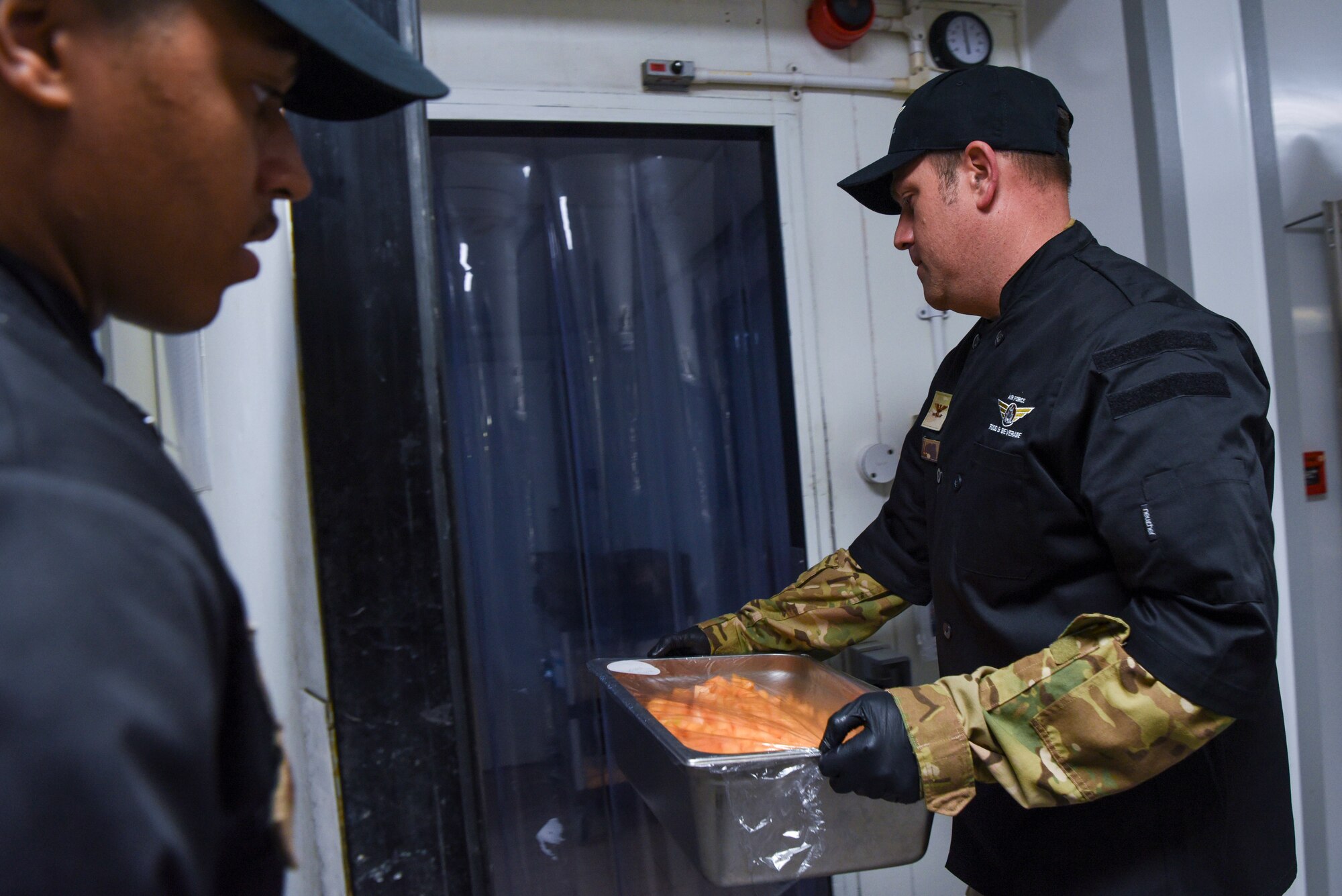 U.S. Air Force Col. Joseph Wall, right, 100th Air Refueling Wing deputy commander, puts cut cantaloupe into a refrigerated area during a “Day in the Life” immersion with the 100th Force Support Squadron Gateway Dining Facility at Royal Air Force Mildenhall, England, Sept. 13, 2024.