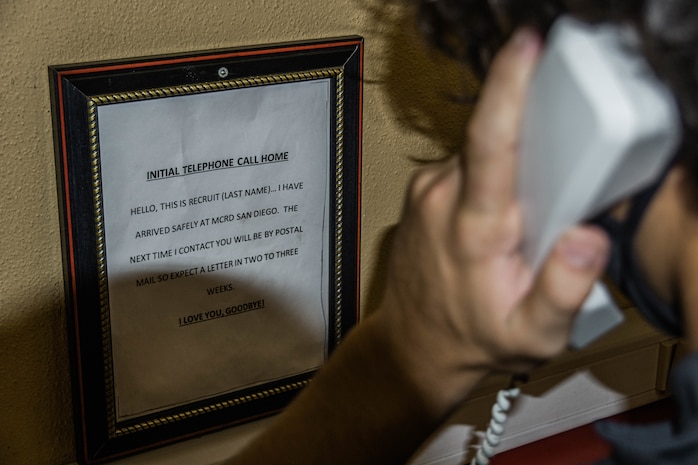 A new U.S. Marine Corps recruit with Kilo Company, 3rd Recruit Training Battalion, makes an initial phone call home as part of the receiving process at Marine Corps Recruit Depot San Diego, California, September 9, 2024. During the receiving process, recruits are checked for contraband, given haircuts, make scripted phone calls home, and issued the gear necessary for recruit training. (U.S. Marine Corps photo by Cpl. Alexandra M. Earl)