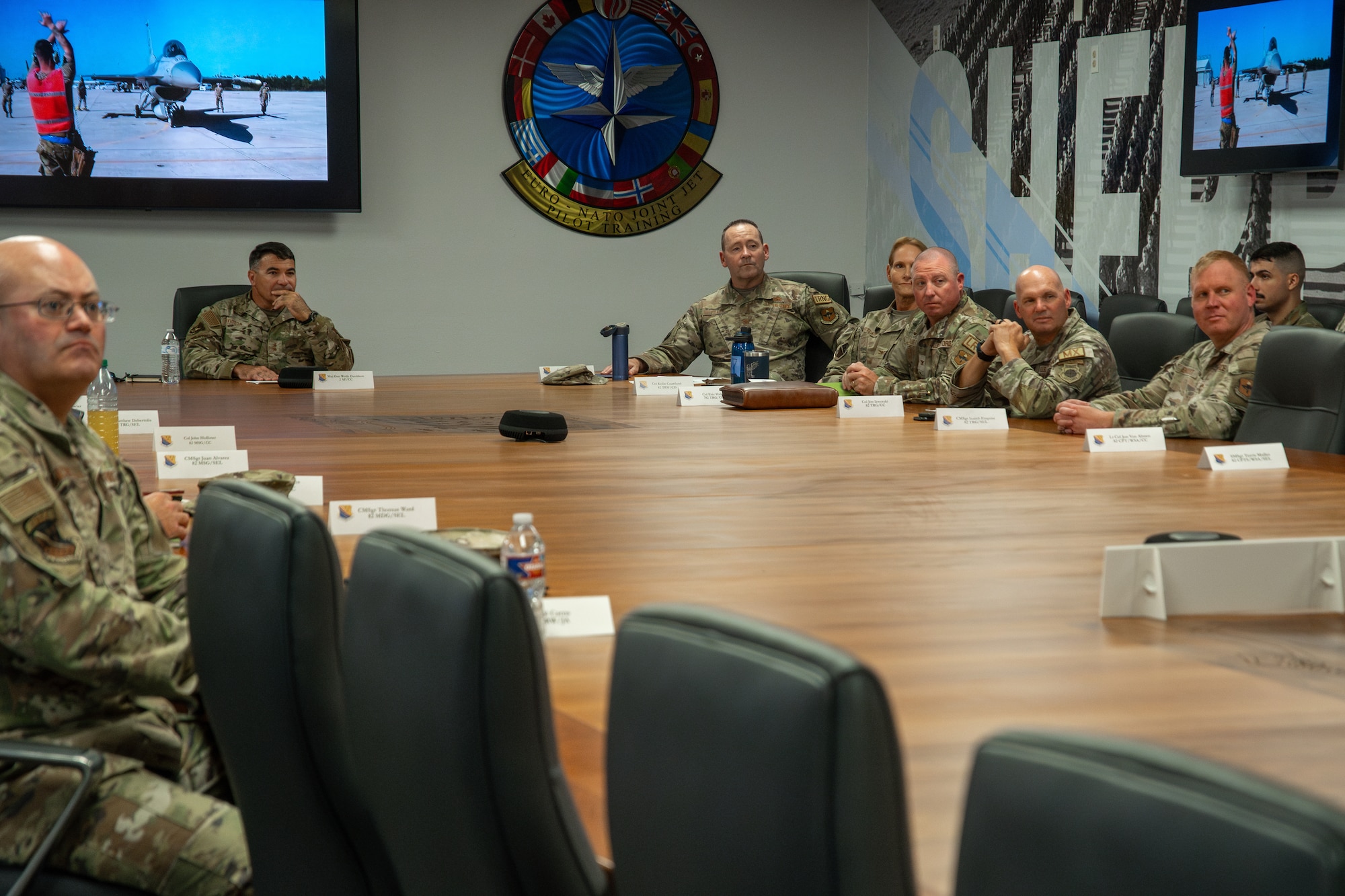People in military attire sit around a conference table