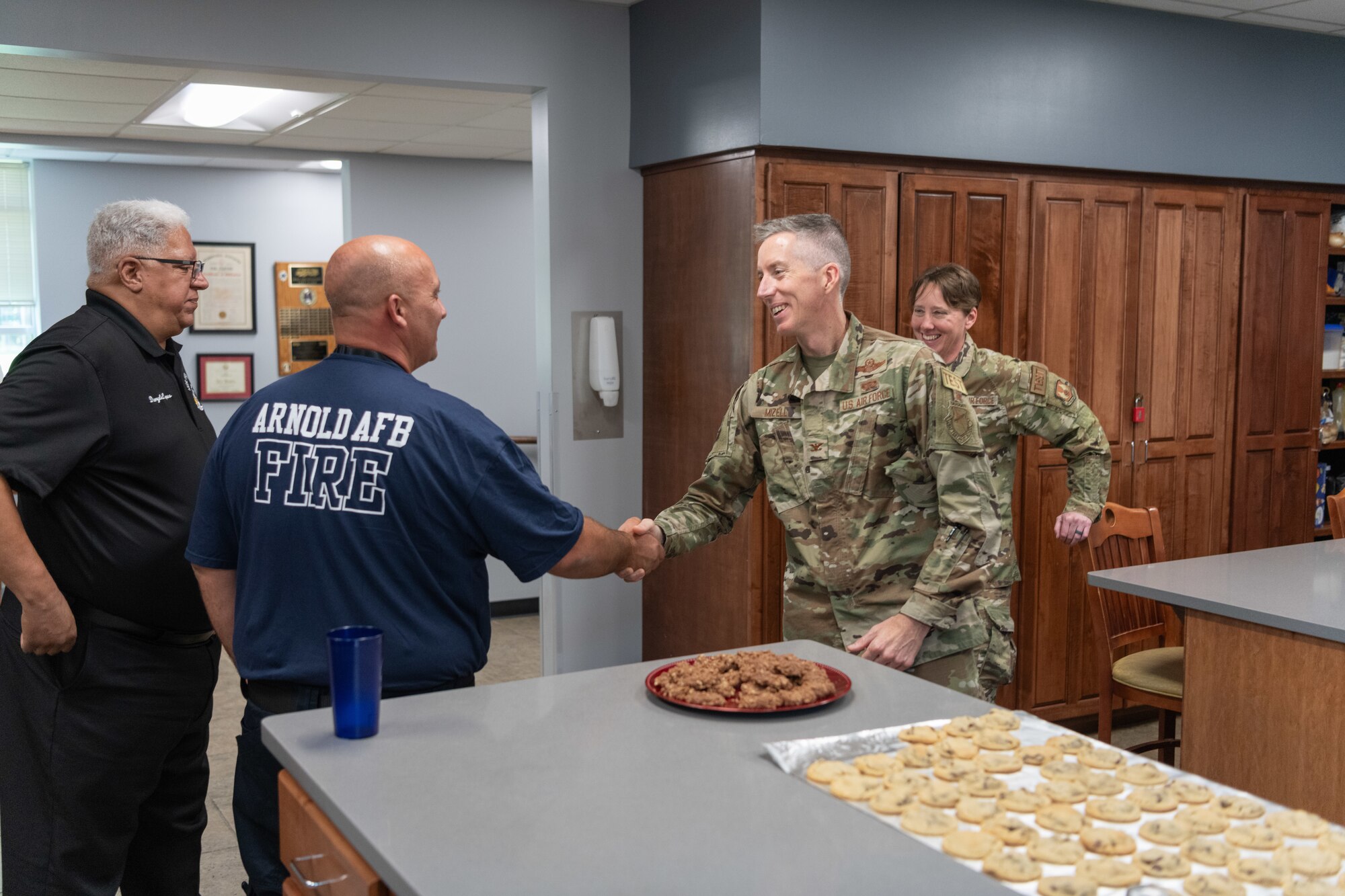 Arnold Engineering Development Complex Commander Col. Grant Mizell, second from right, shakes hands with Arnold Air Force Base Fire and Emergency Services firefighter Kevin Madachik during Mizell’s Aug. 9, 2024, visit to the Arnold AFB FES station for his first Commander’s Cookie Day. Madachik has been making chocolate chip cookies for the FES crew for around five years. When Mizell’s predecessor caught wind of this, he began scheduling cookie days with Arnold FES to meet and talk with crew members. Mizell wanted to continue this tradition. Also pictured is Arnold FES Chief Daryle Lopes and AEDC Senior Enlisted Leader Chief Master Sgt. Jennifer Cirricione. (U.S. Air Force photo by Keith Thornburgh)