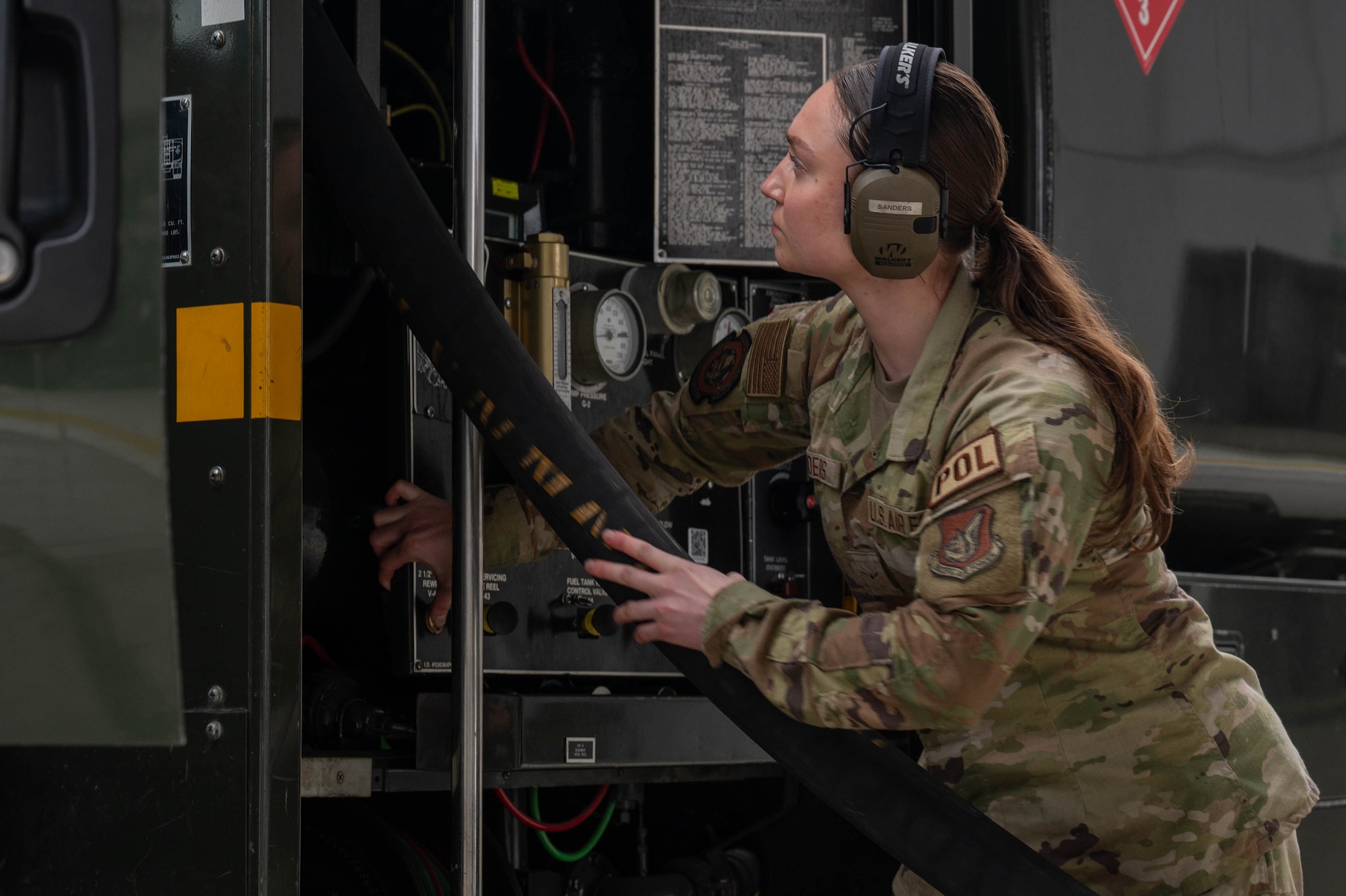 U.S. Air Force Airman Kaelin Sanders, 354th Logistics Readiness Squadron fuels operator, assists the retraction of a fueling hose into an R11 aircraft refueling vehicle at Eielson Air Force Base, Alaska, Sept. 12, 2024.
