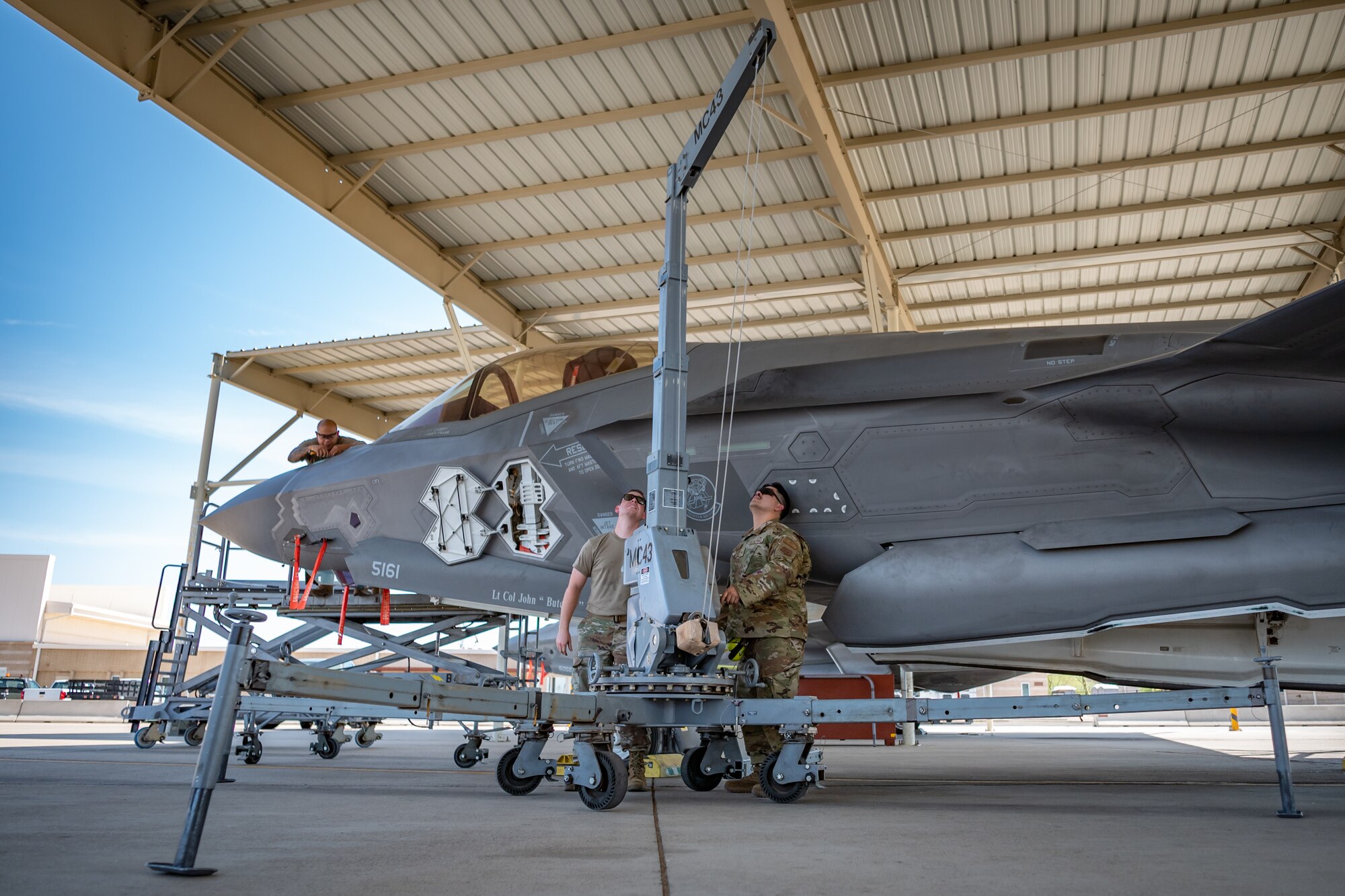 Reserve Citizen Airmen from the 944th Maintenance Group operate a hoist while performing maintenance on an F-35 fighter jet at Luke Air Force Base, Ariz., Sept. 8, 2024. The maintainers' work ensures the aircraft remain operational in high temperatures. (U.S. Air Force photo by Tech. Sgt. Tyler J. Bolken)