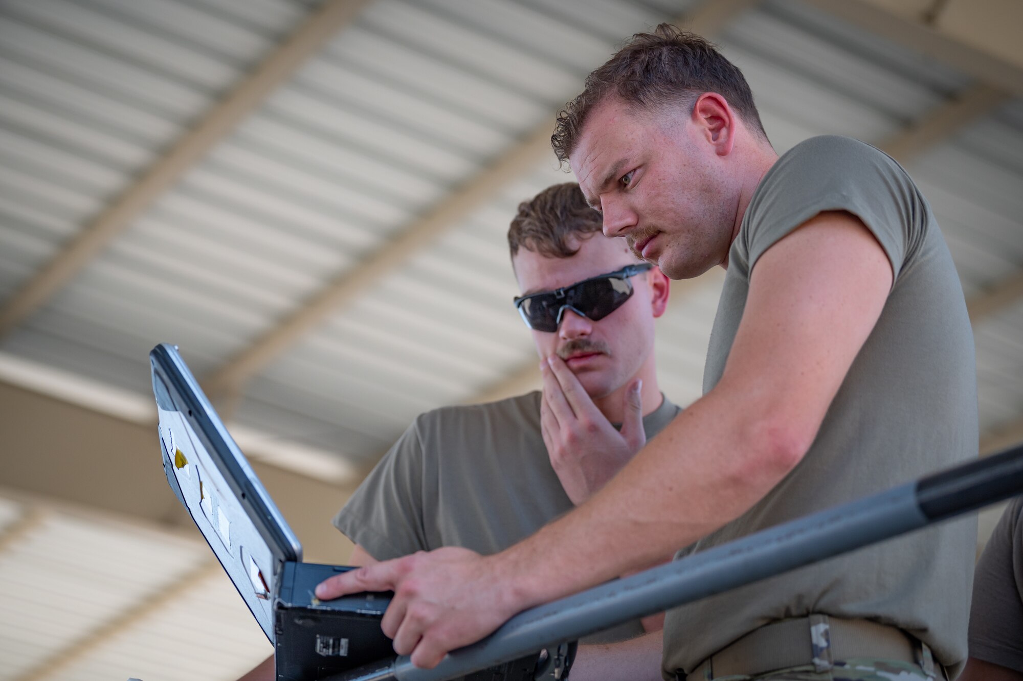 Two Reserve Citizen Airmen review technical data on a laptop while working on an F-35 on the flight line at Luke Air Force Base, Ariz., Sept. 8, 2024. The integration of technology plays a vital role in maintaining modern aircraft. (U.S. Air Force photo by Tech. Sgt. Tyler J. Bolken)